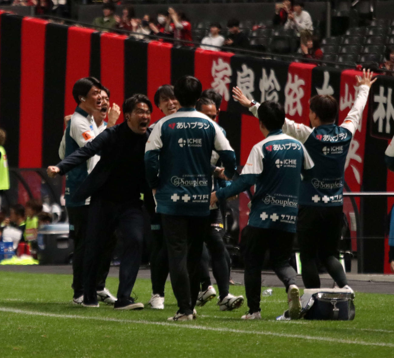 勝利が決まり、スタッフと喜ぶ札幌岩政監督（左端）（撮影・保坂果那）