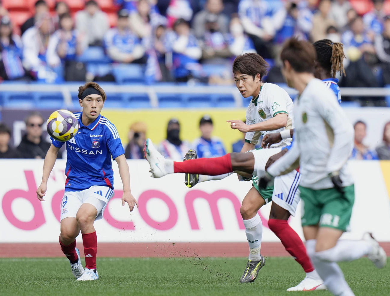 横浜対東京V　前半、クロスを上げる東京V・染野（右奥）（共同）