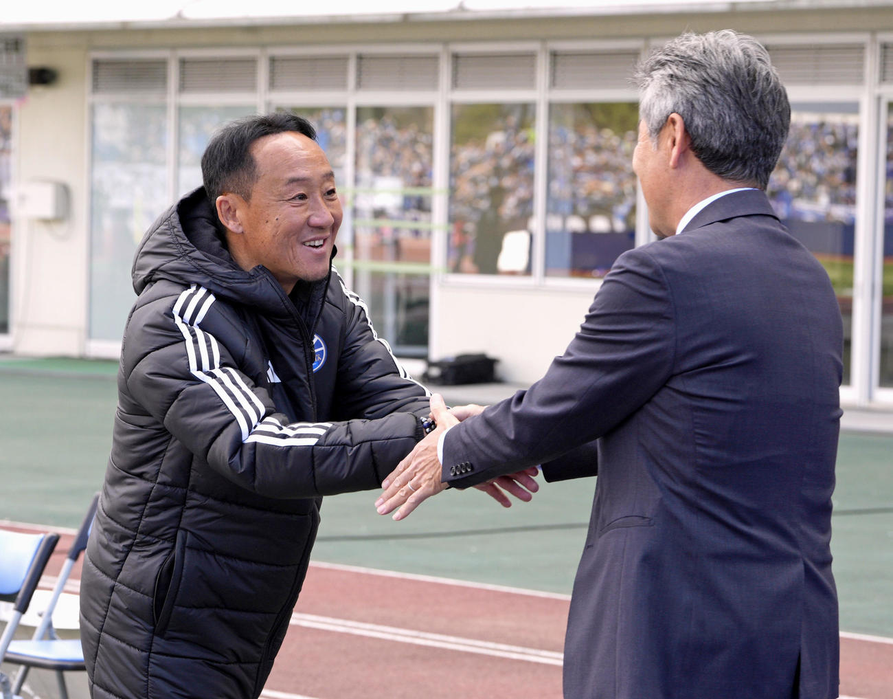 試合前、川崎F長谷部監督と握手を交わす町田・黒田監督（左）（共同）