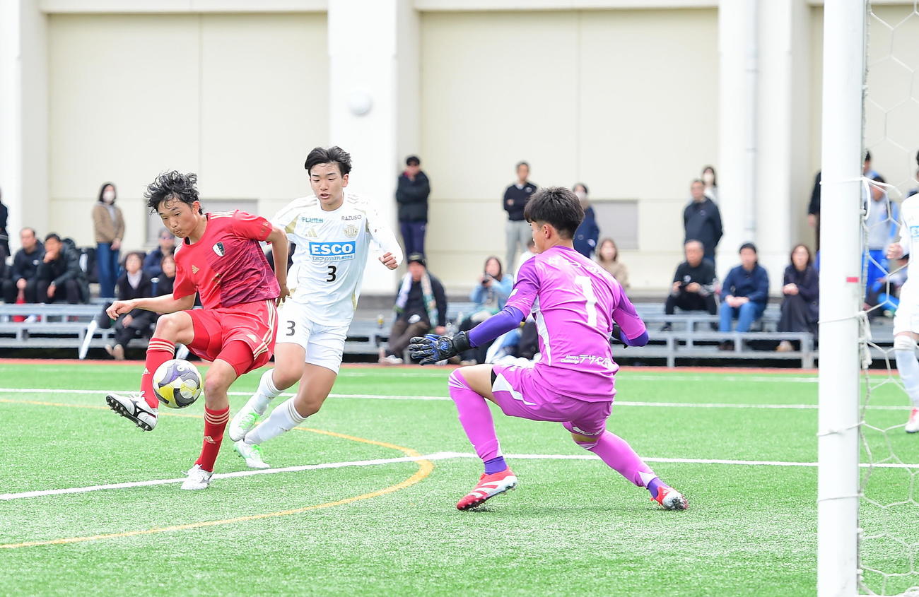 右足で先制点を決める新潟明訓・鈴木快（左）（撮影・小林忠）