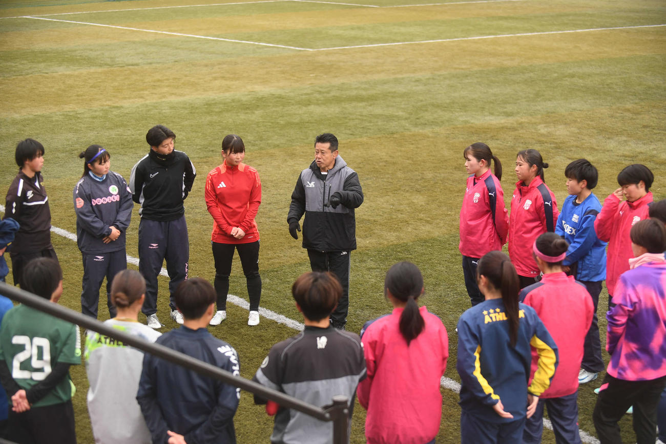 練習後、真剣な表情で選手に話す鈴木監督（正面左から5人目）
