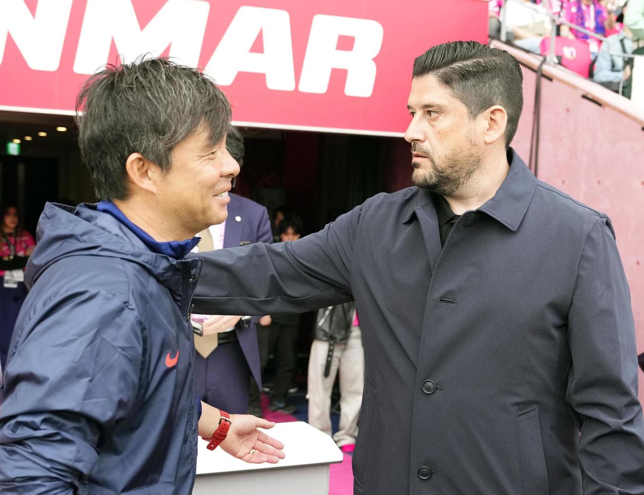 試合前、あいさつを交わす鹿島・鬼木監督（左）とC大阪・パパス監督（共同）
