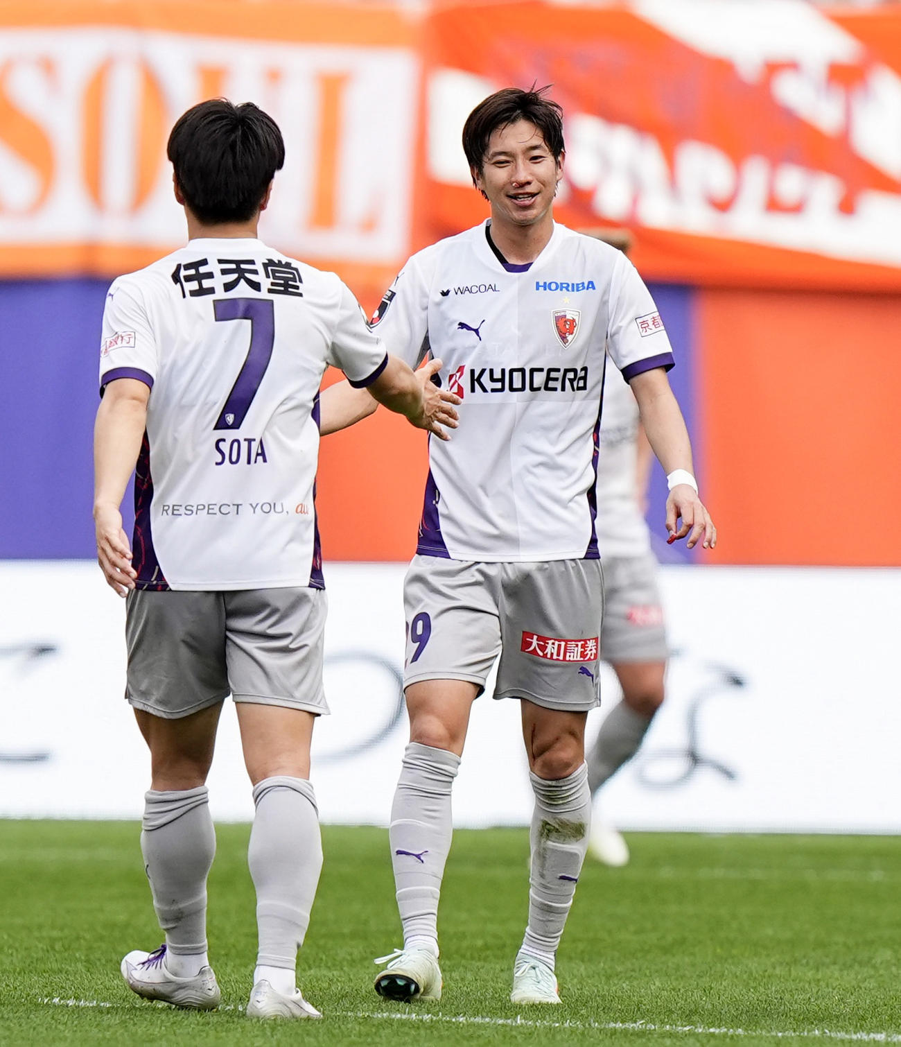 新潟に勝利し、川崎（7）とタッチを交わす京都・奥川（共同）
