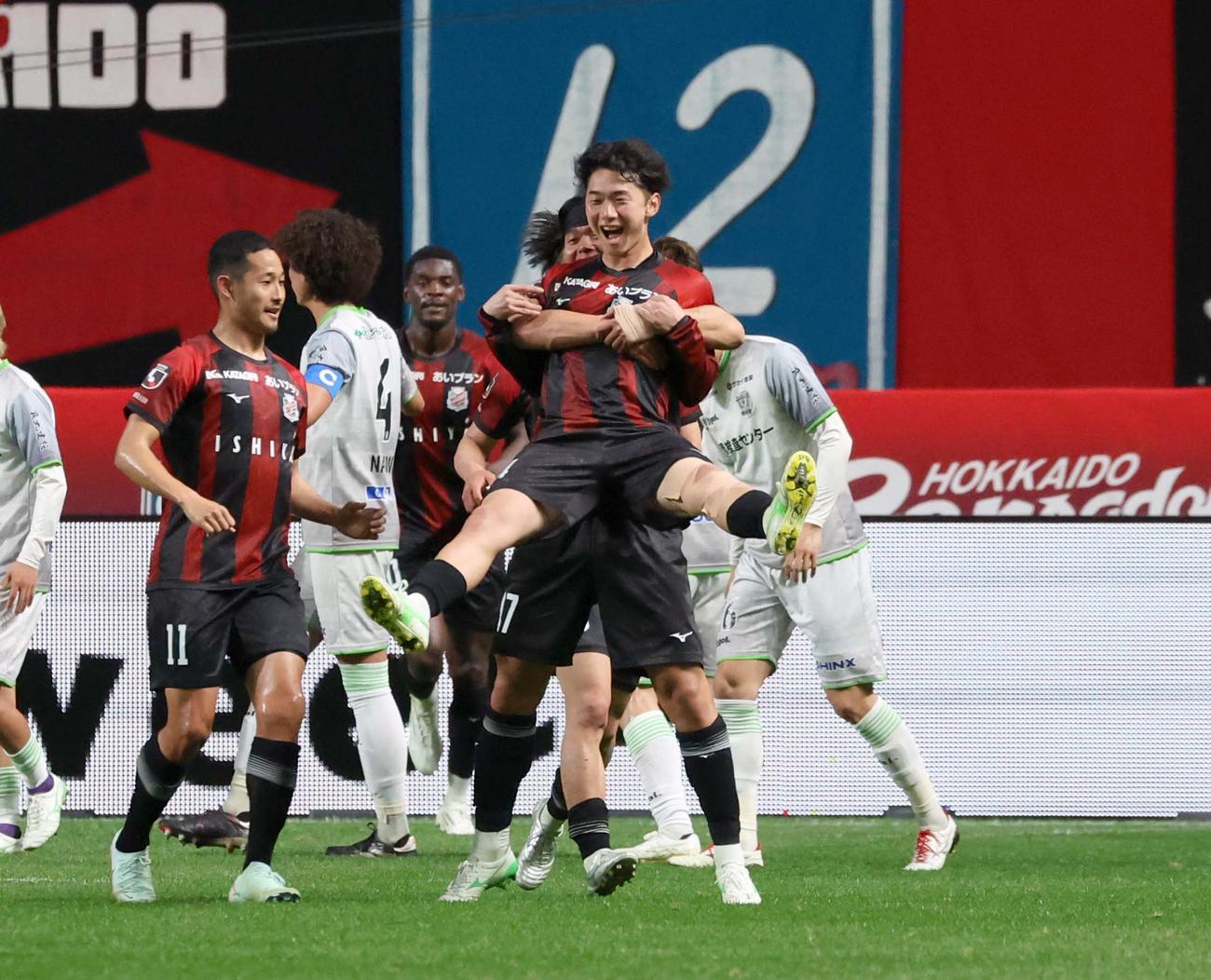札幌対藤枝　前半、フリーキックでゴールを決めた札幌田中克は抱きかかえられ笑顔を見せる（撮影・黒川智章）