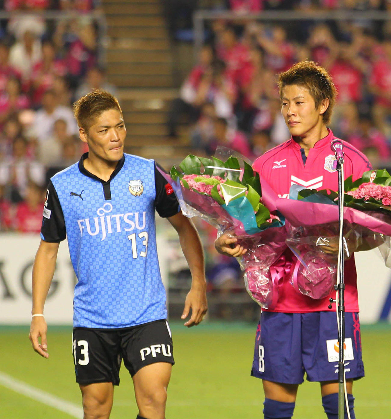 バーゼルに移籍する柿谷曜一朗に花束を手渡した川崎FのFW大久保嘉人（左）＝2014年7月