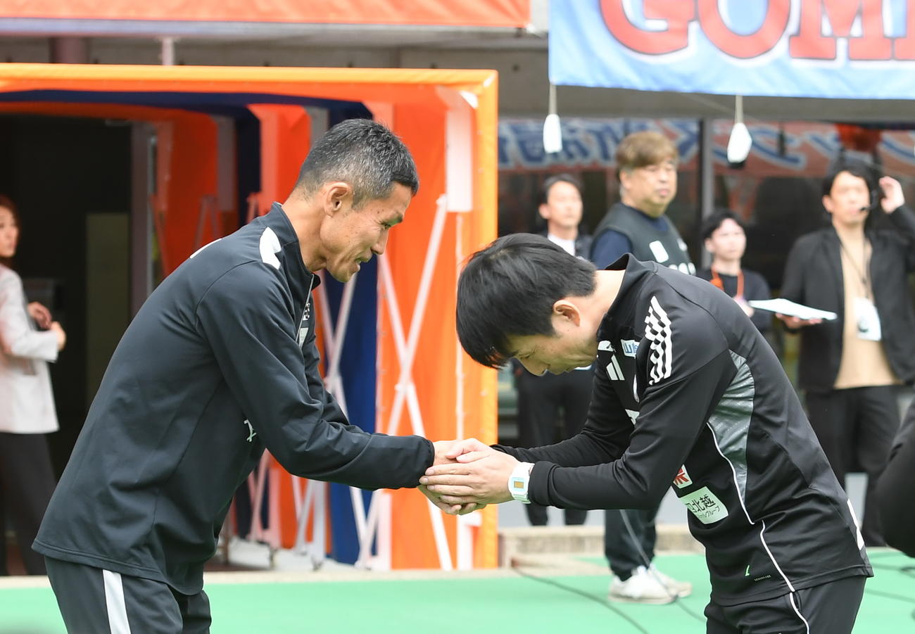 試合前に握手を交わす東京松橋監督（左）と新潟樹森監督（撮影・小林忠）