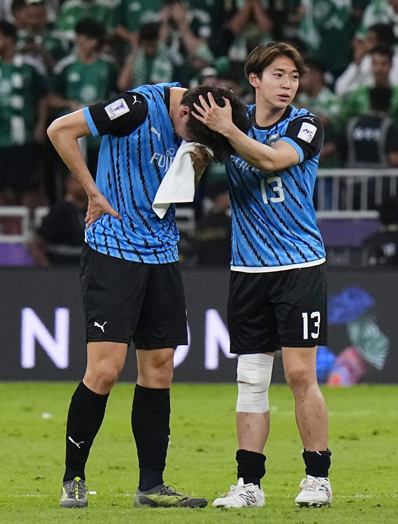 アルアハリに敗れ、涙ぐむ高井を慰める川崎F三浦（右）（共同）