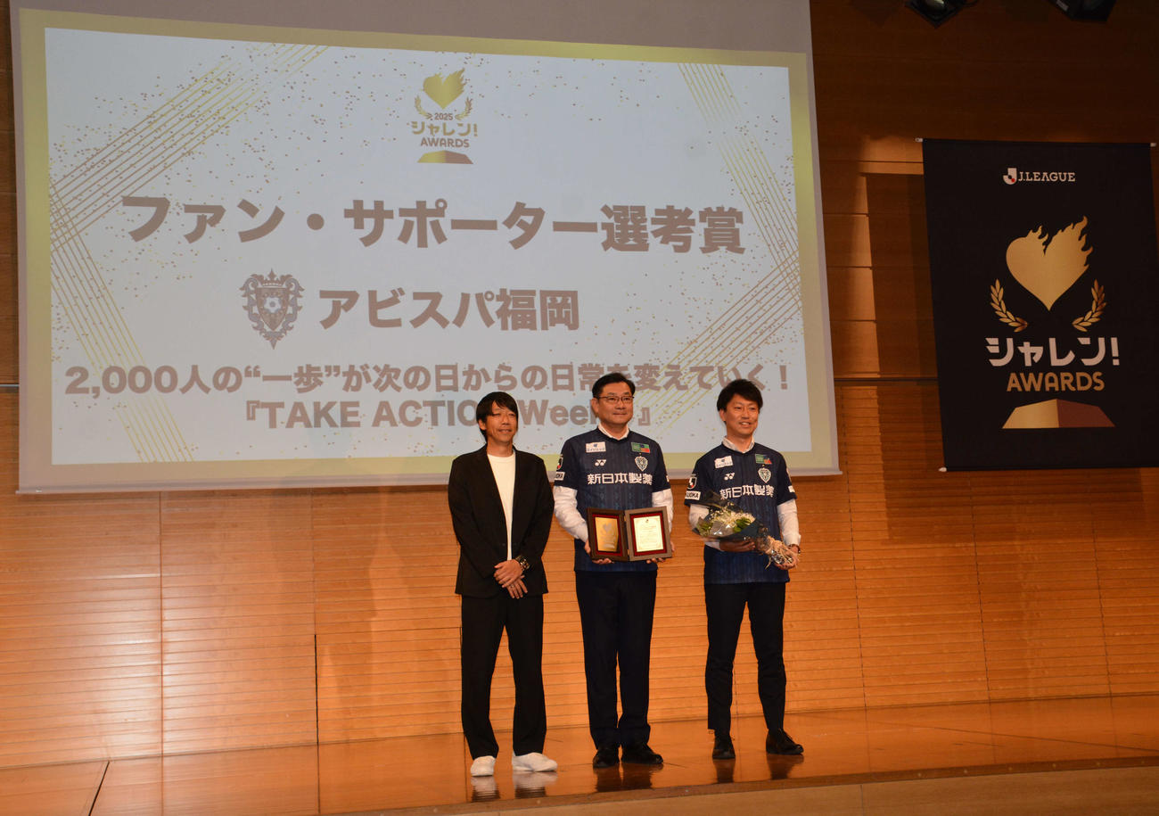 ファン・サポーター選考を受賞したアピスパ福岡・川森実行委員（中央）、佐川担当。左はプレゼンターの中村憲剛Jリーグ特任理事