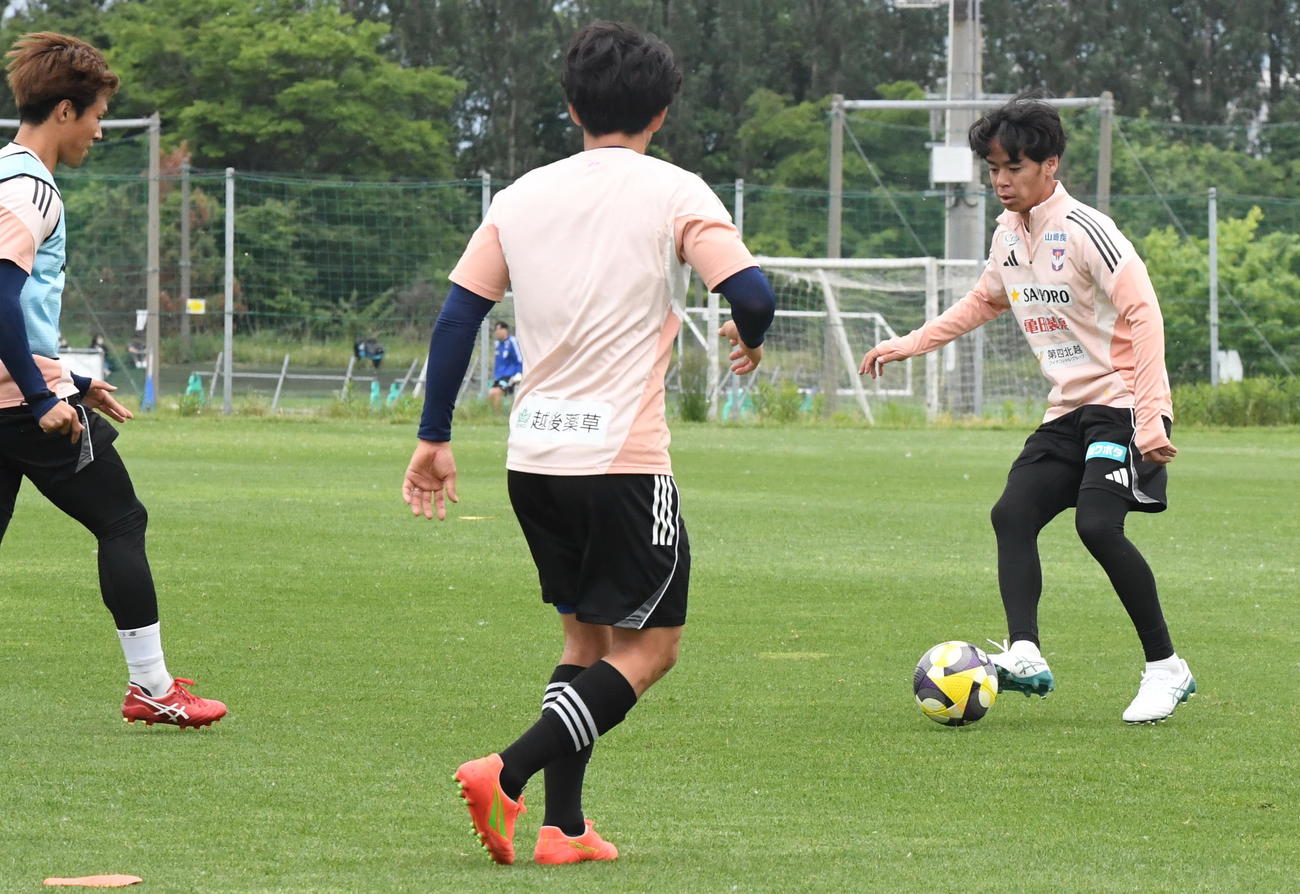 古巣新潟の練習に参加し、パスを出すシントトロイデン伊藤（右）（撮影・小林忠）