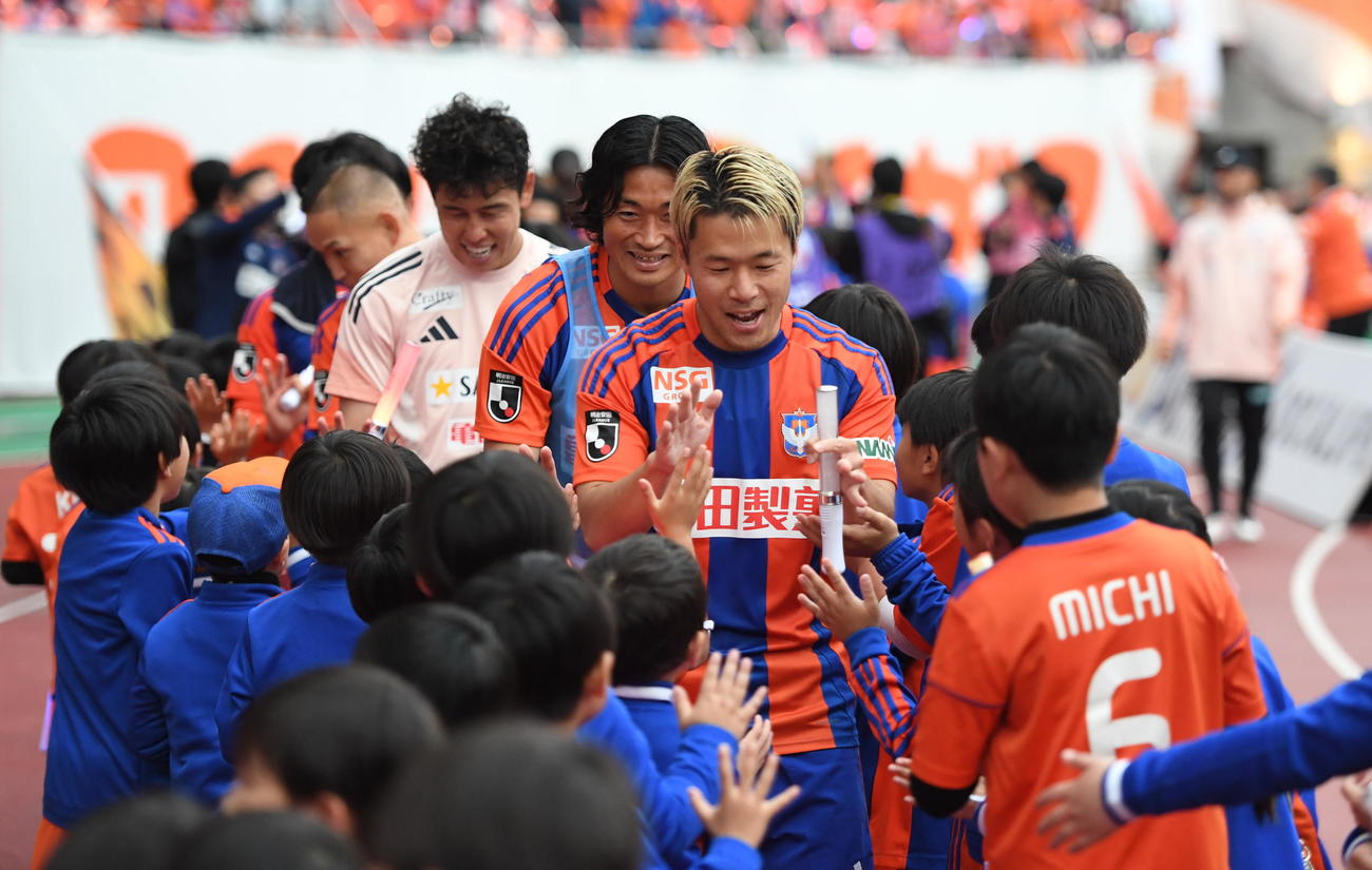 試合終了後、スクール生とタッチする新潟・堀米主将（中央）（撮影・小林忠）