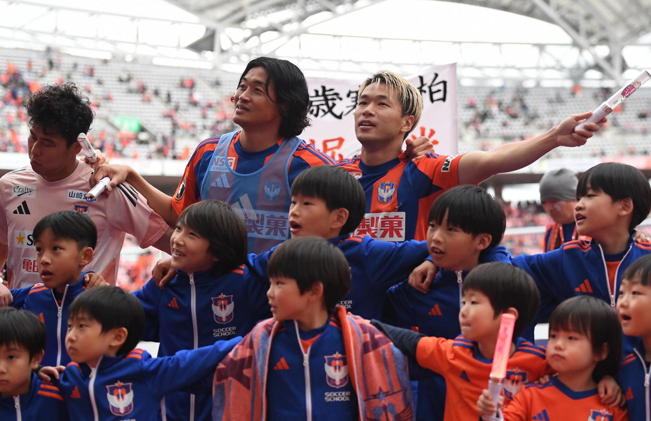 試合終了後、サポーターと勝利の喜びを共有する新潟・堀米主将（後列右）（撮影・小林忠）
