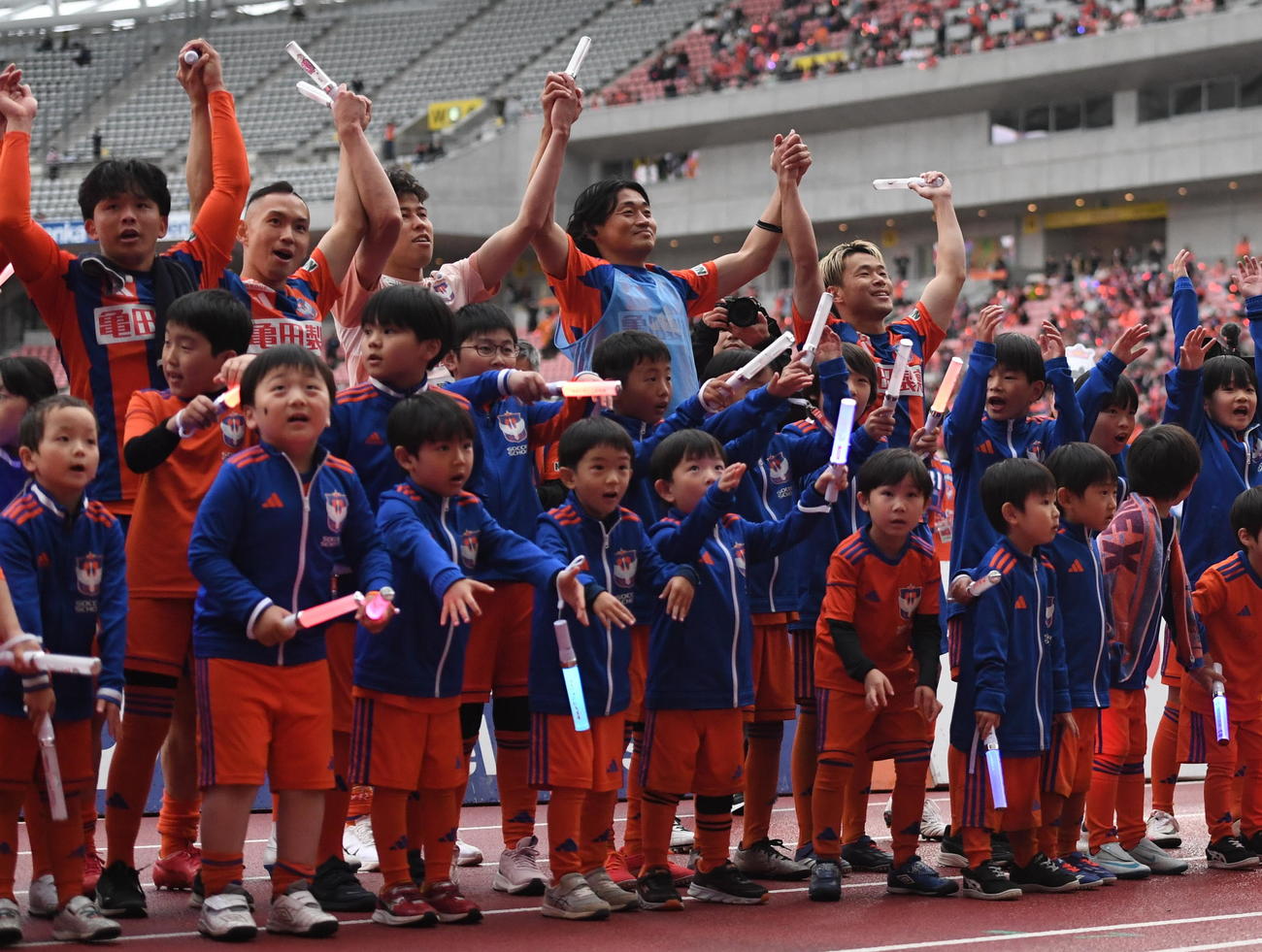 試合終了後、サポーターと勝利の喜びを共有する新潟・堀米主将（後列右）（撮影・小林忠）