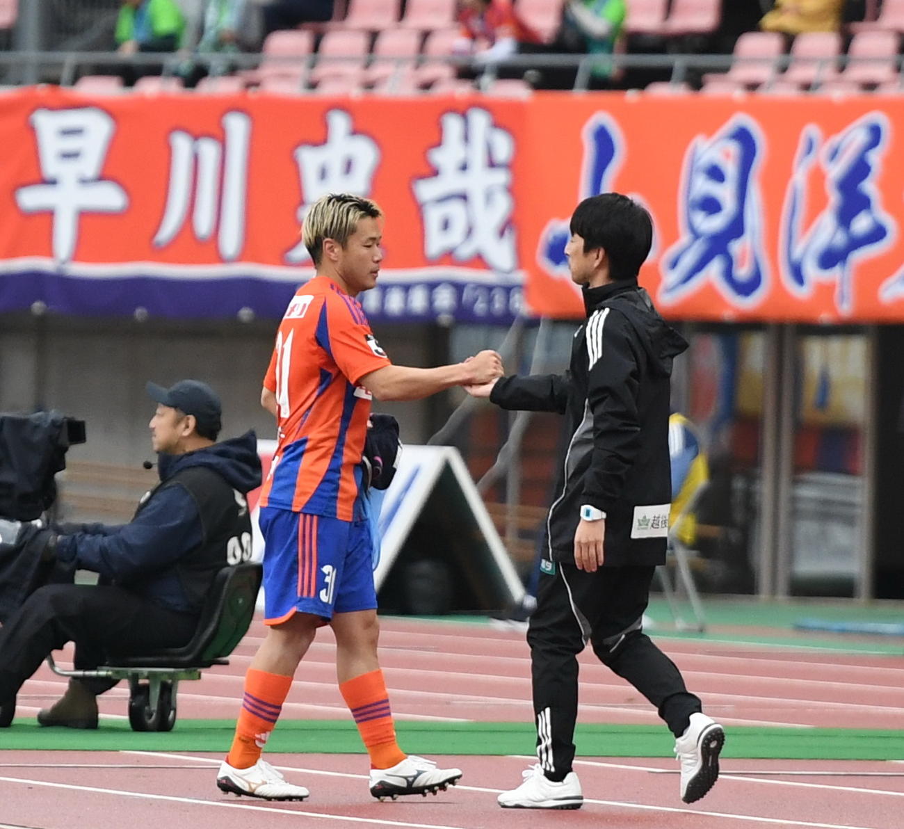試合終了後、握手を交わす新潟・堀米主将（左）と樹森監督（撮影・小林忠）