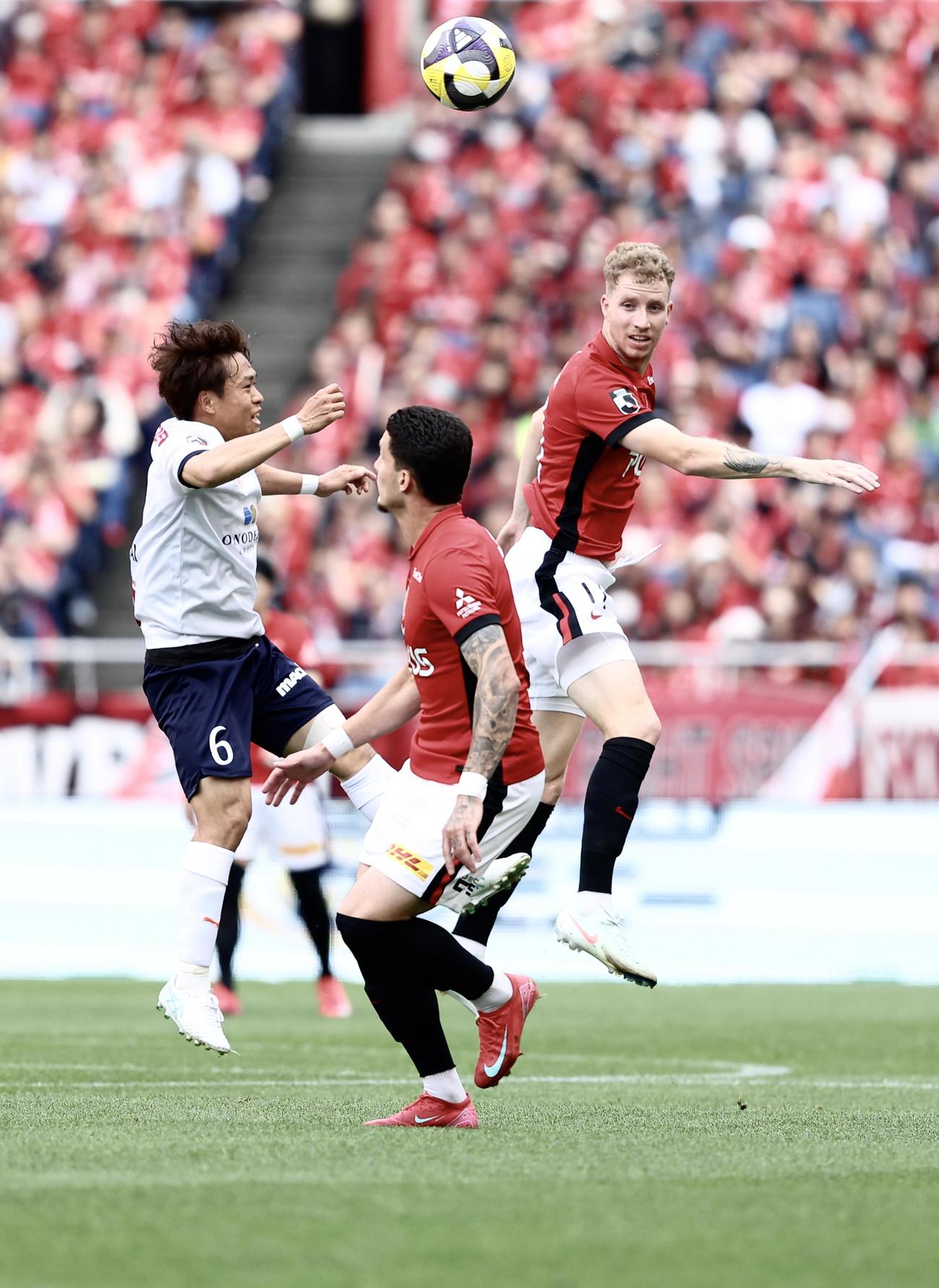 浦和対横浜FC　競り合う横浜FC・FW駒井（左）と浦和MFグスタフソン（撮影・河田真司）