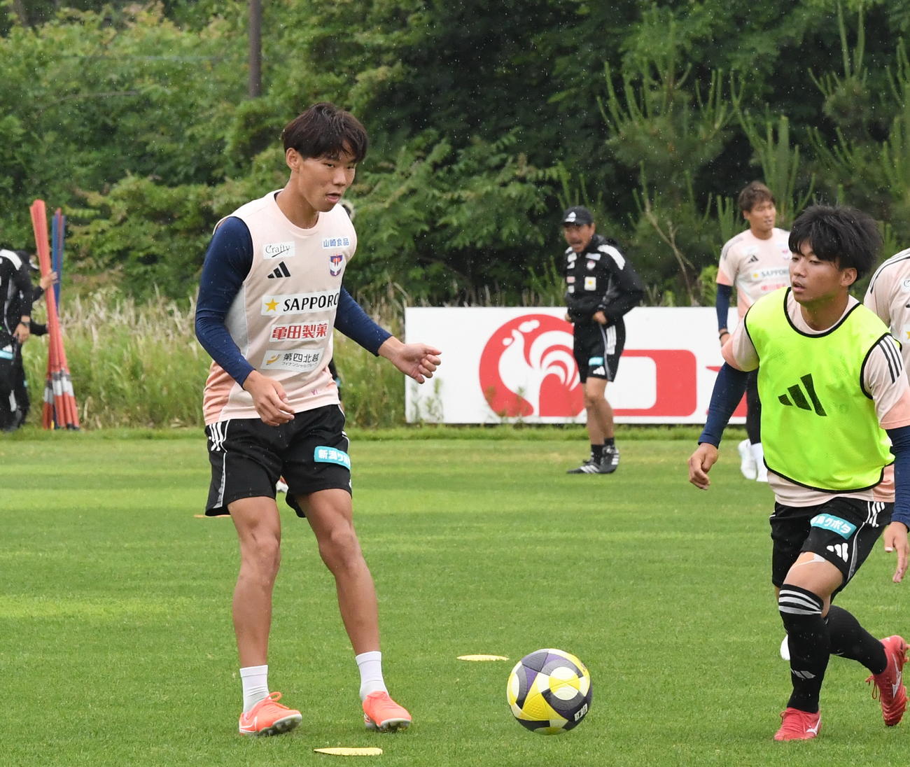 ホーム横浜戦前日練習でパスを出す新潟・稲村（左）（撮影・小林忠）