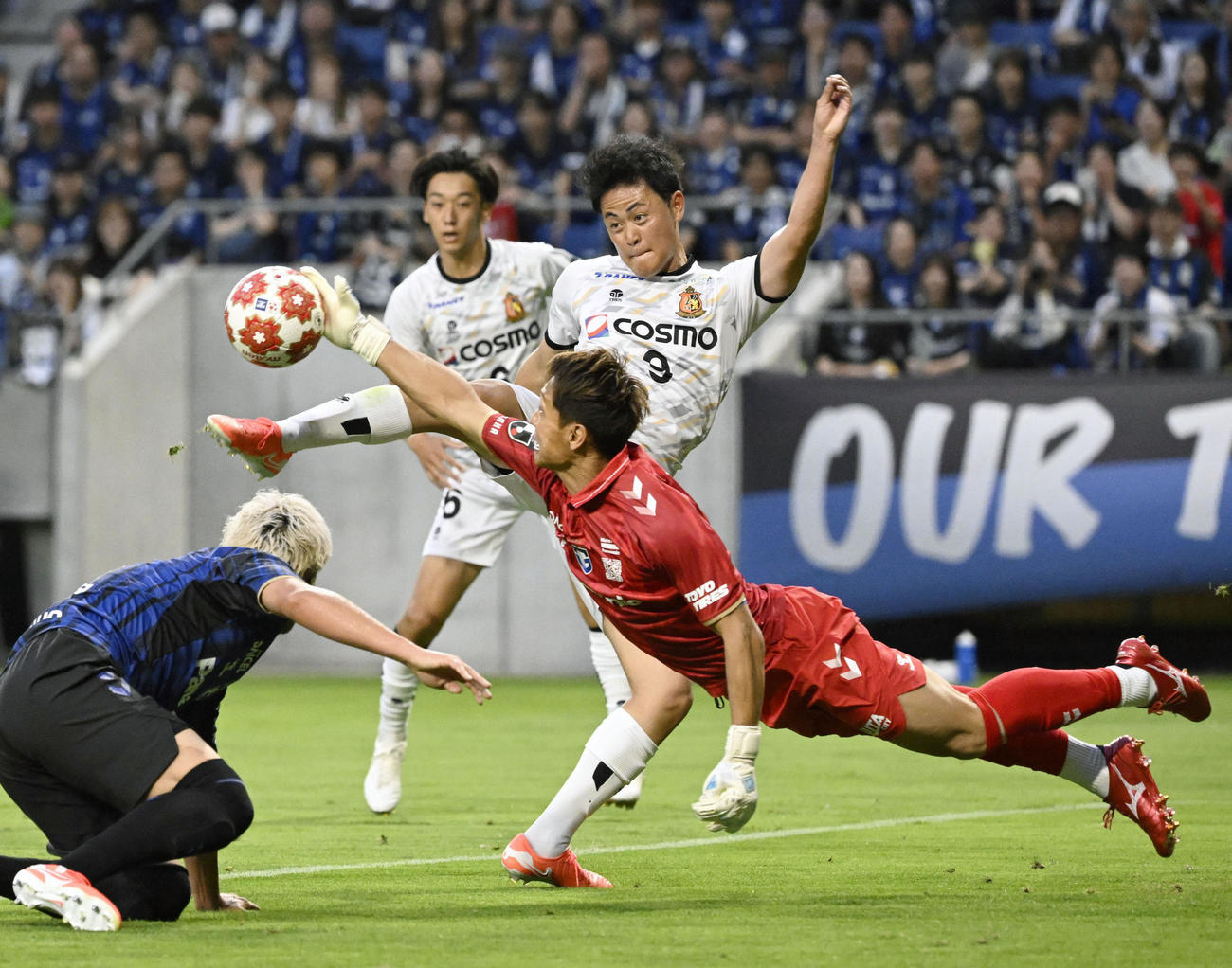 前半、競り合うヴィアティン三重・大竹（上）とG大阪のGK一森（共同）
