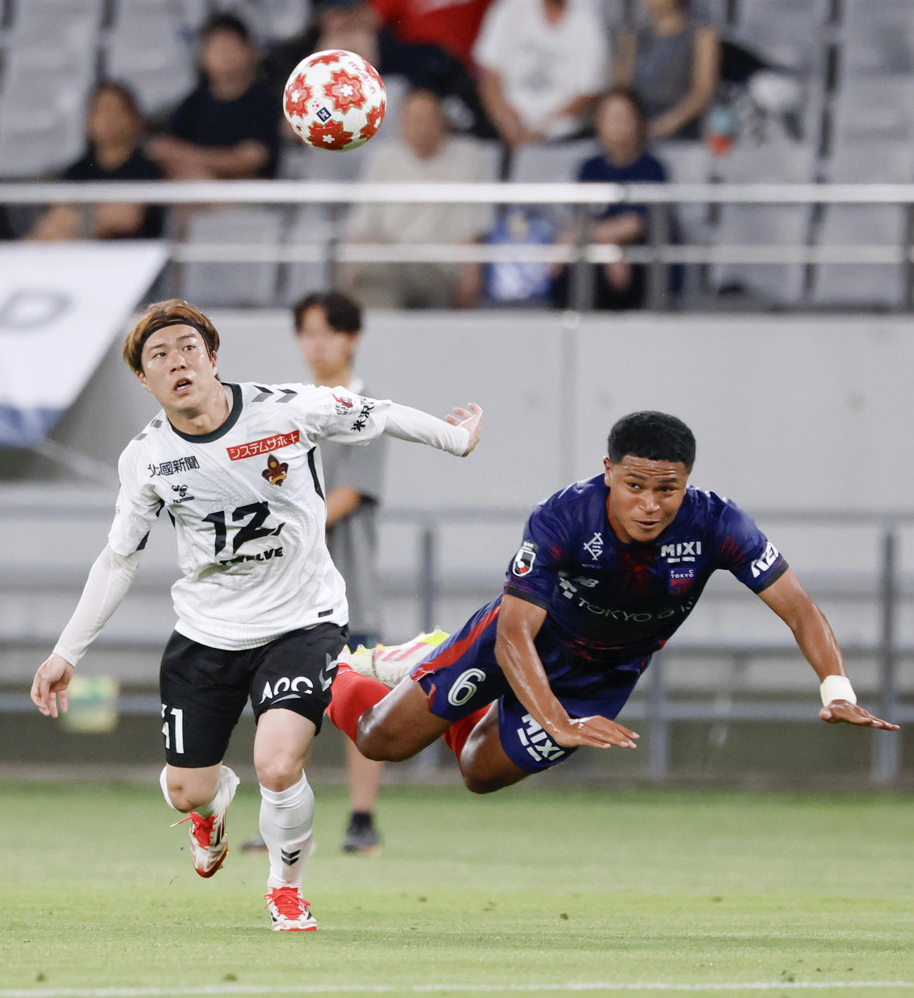 前半、競り合う東京バングーナガンデ（右）と金沢嶋田（共同）
