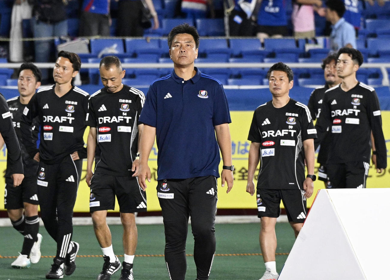 岡山に敗れ、サポーターのもとへあいさつに向かう横浜大島監督（中央、共同）