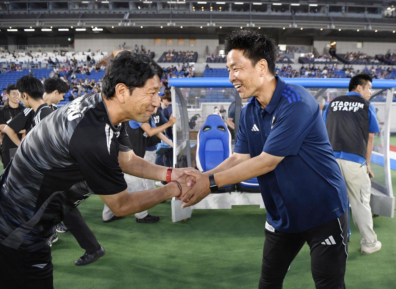 試合開始前、握手を交わす岡山木山監督（左）と横浜大島監督(共同)
