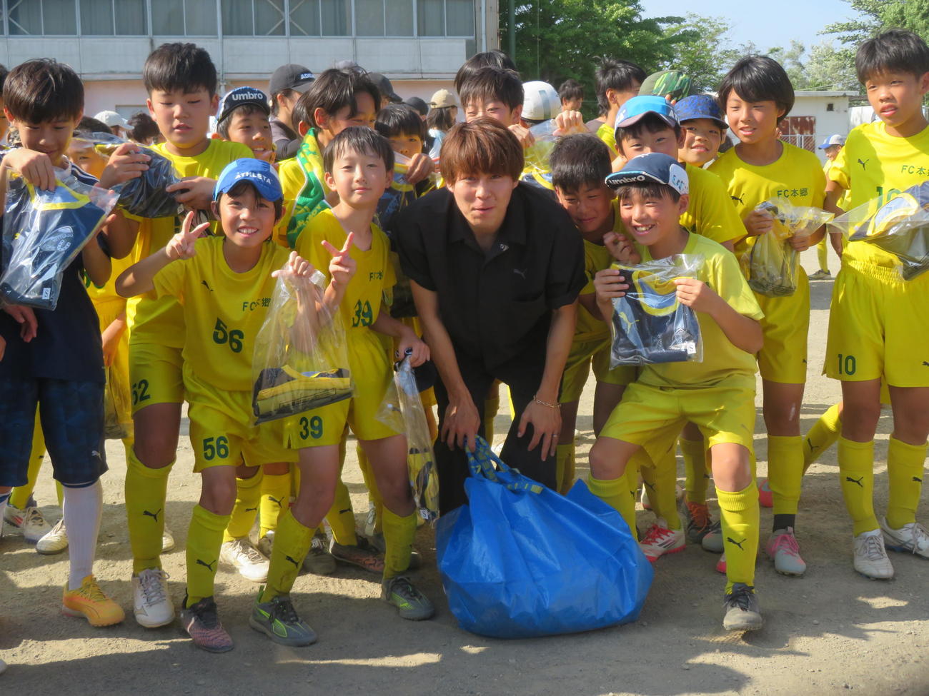 小学時代に在籍したFC本郷を訪れ、練習着約100枚を寄贈した川崎フロンターレMF脇坂泰斗（前列中央）（撮影・佐藤成）