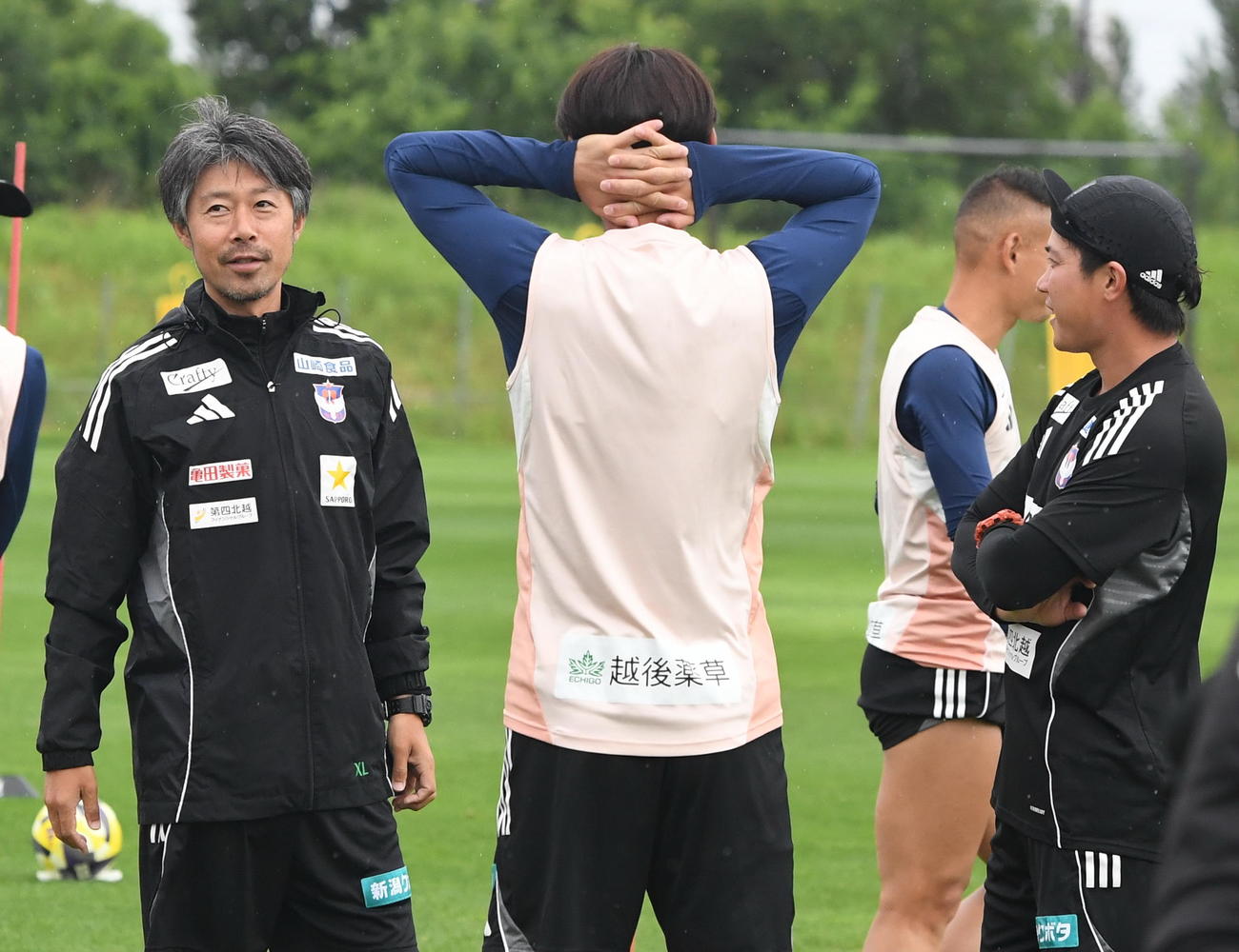 川崎F戦の前日練習開始前に談笑する新潟本間新コーチ（左）（撮影・小林忠）