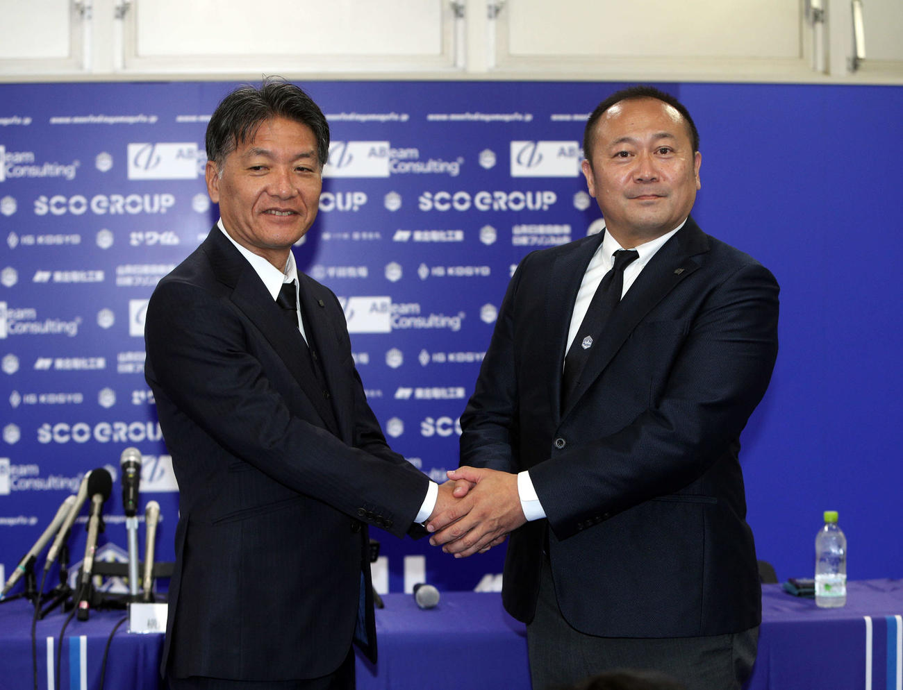 握手する横内新監督（左）と相田社長（撮影・木村有優）