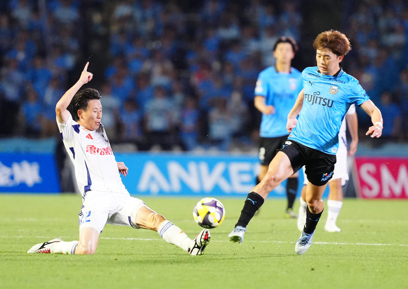川崎F対新潟　前半、ボールをカットする新潟新井（左）。右は川崎F山本（撮影・江口和貴）