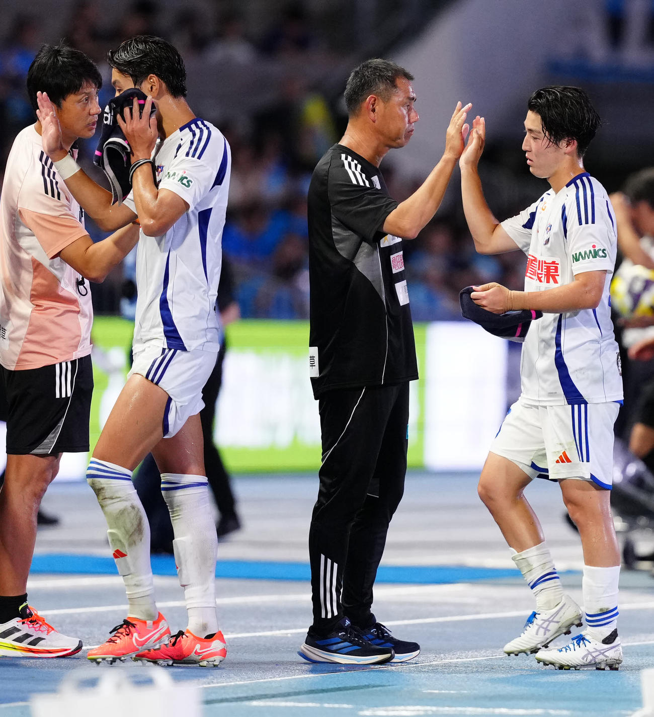 川崎F対新潟　試合後、選手たちを出迎える新潟入江監督（中央）（撮影・江口和貴）