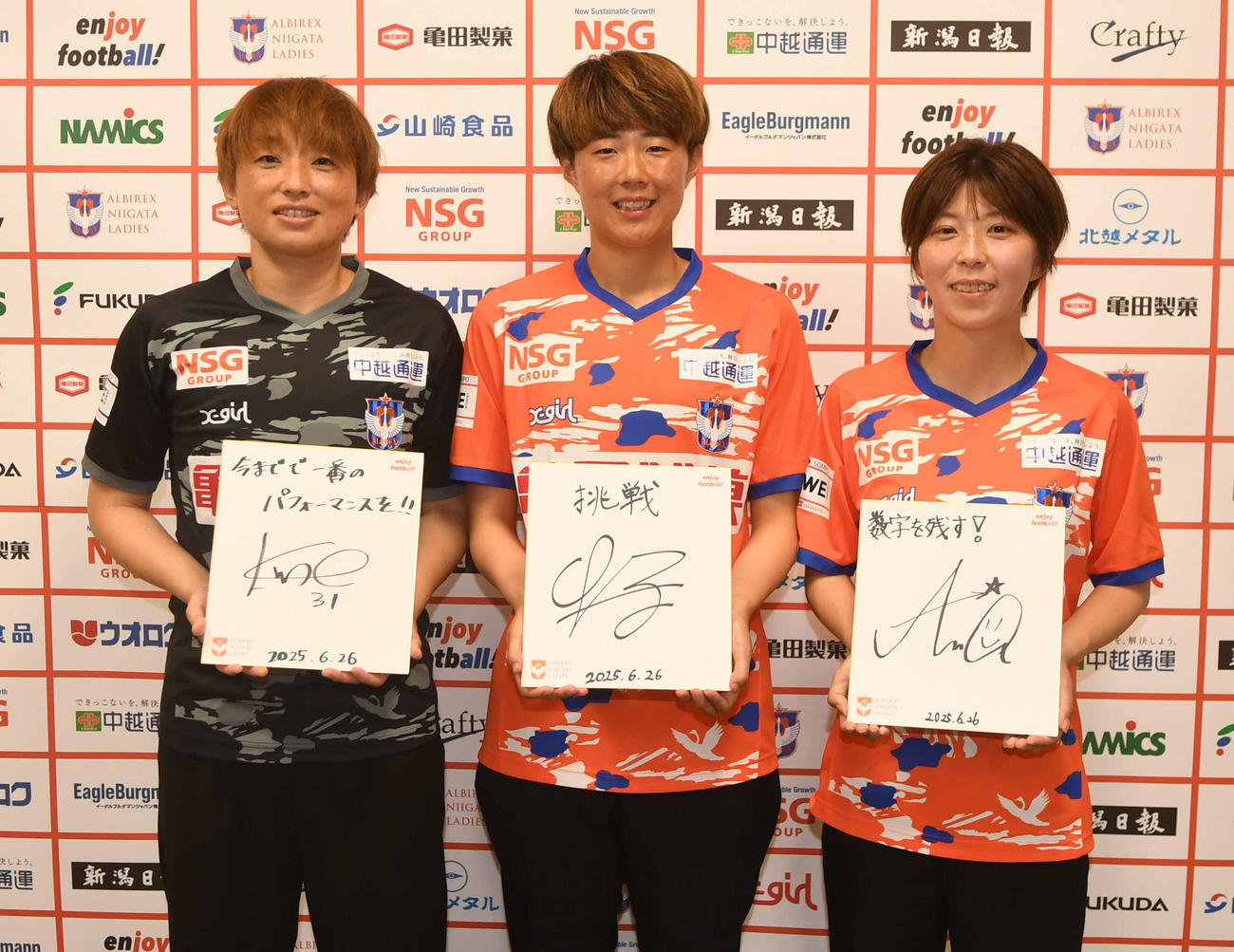 今季のテーマを記した色紙を掲げる新潟Lの新戦力。左から久野、城和、江崎