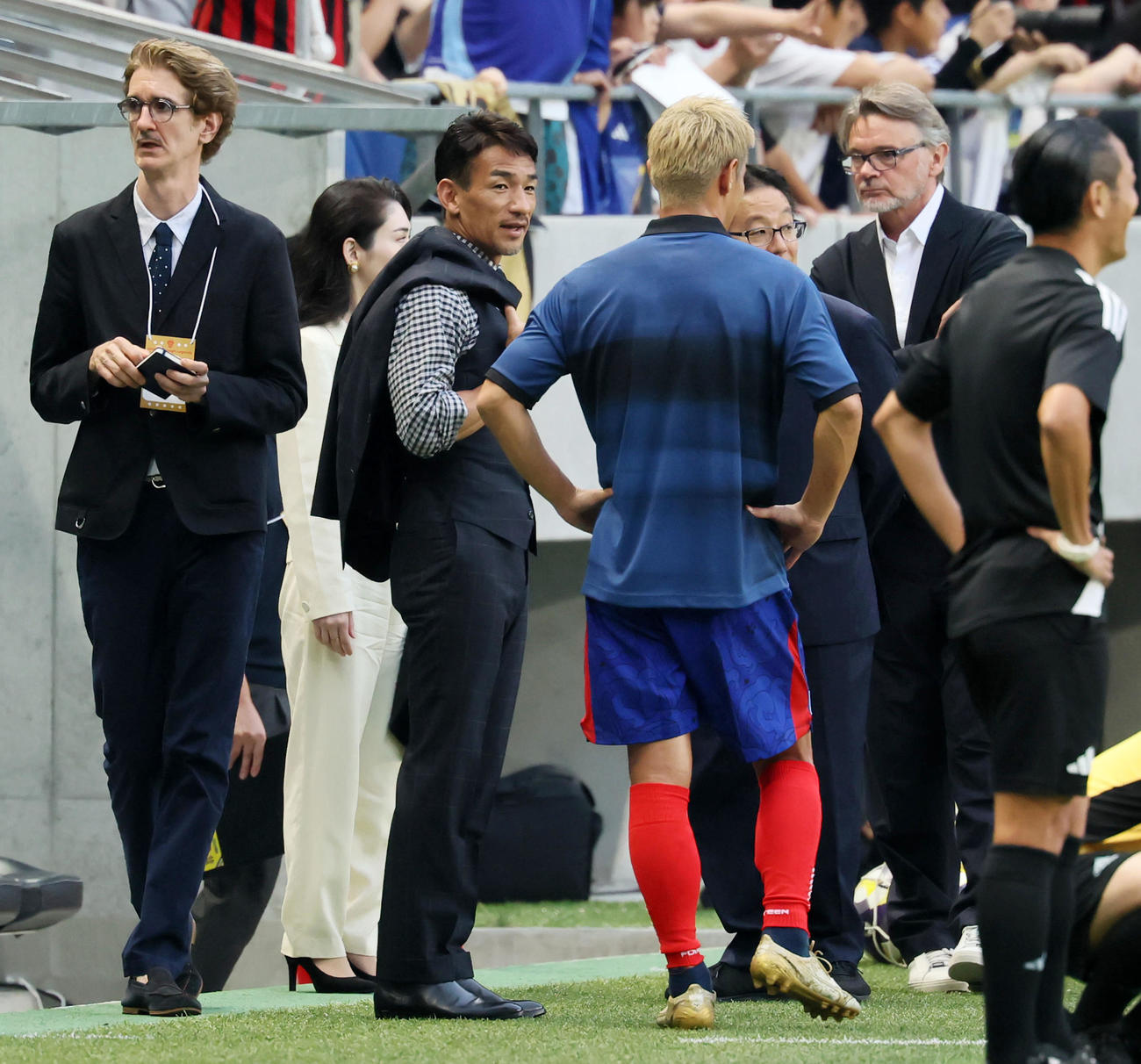 日本レジェンド対モナコレジェンド　試合前本田（背中）を中心に談笑する左は中田氏、右はトルシエ監督。左端は通訳のダバティ氏（撮影・加藤哉）
