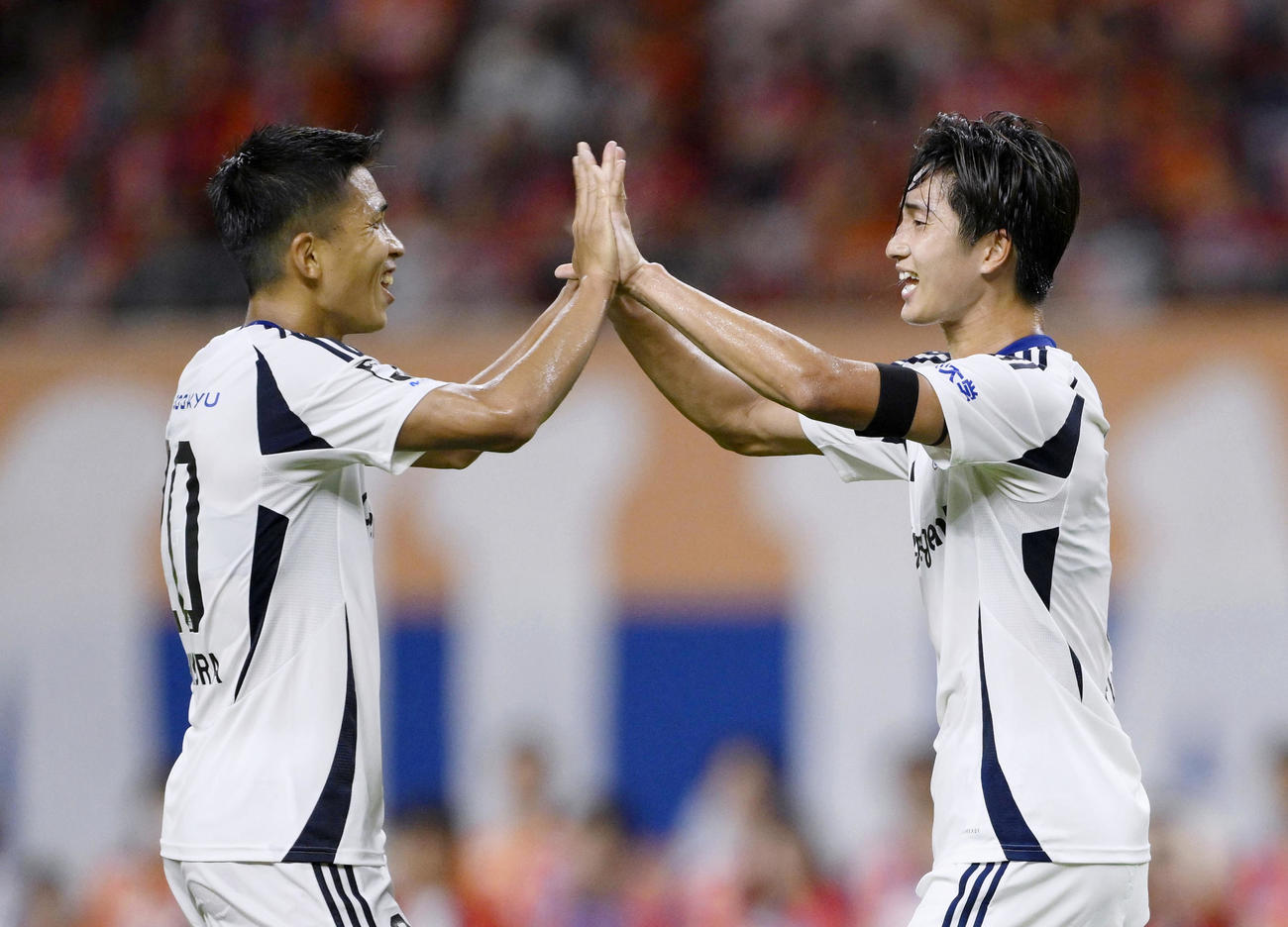 新潟―町田　後半、チーム4点目のゴールを決め、西村とタッチを交わす町田・藤尾（右）＝デンカ(共同)