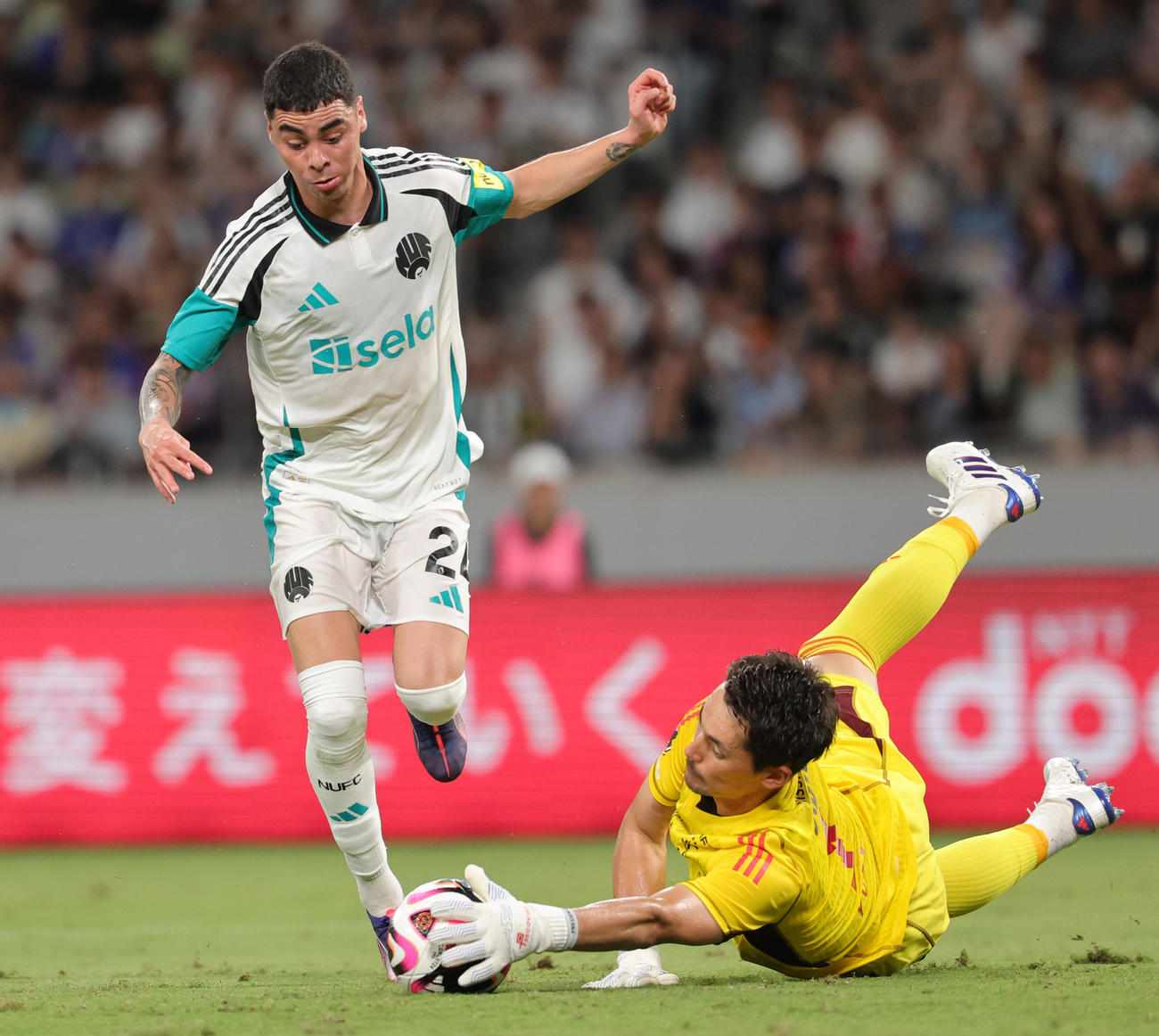 24年8月3日　横浜対ニューカッスル　後半、ニューカッスルのアルミロン（左）の突破に対応する横浜GKポープ（撮影・野上伸悟）