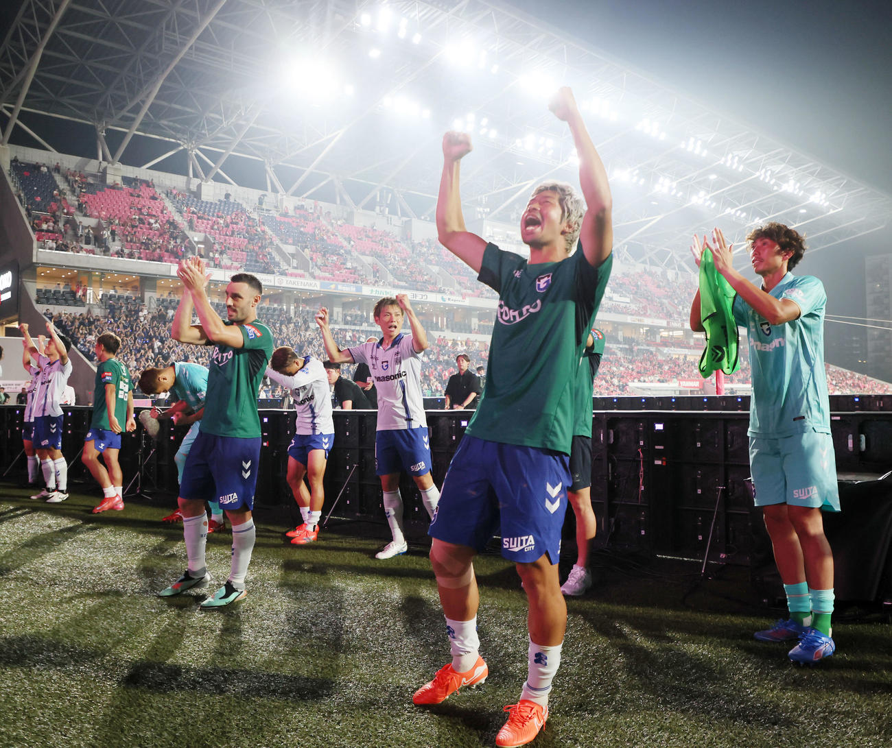 C大阪対G大阪　C大阪に勝利しサポーターを前にガッポーズを見せるG大阪三浦（右）と左はラビ（撮影・加藤哉）