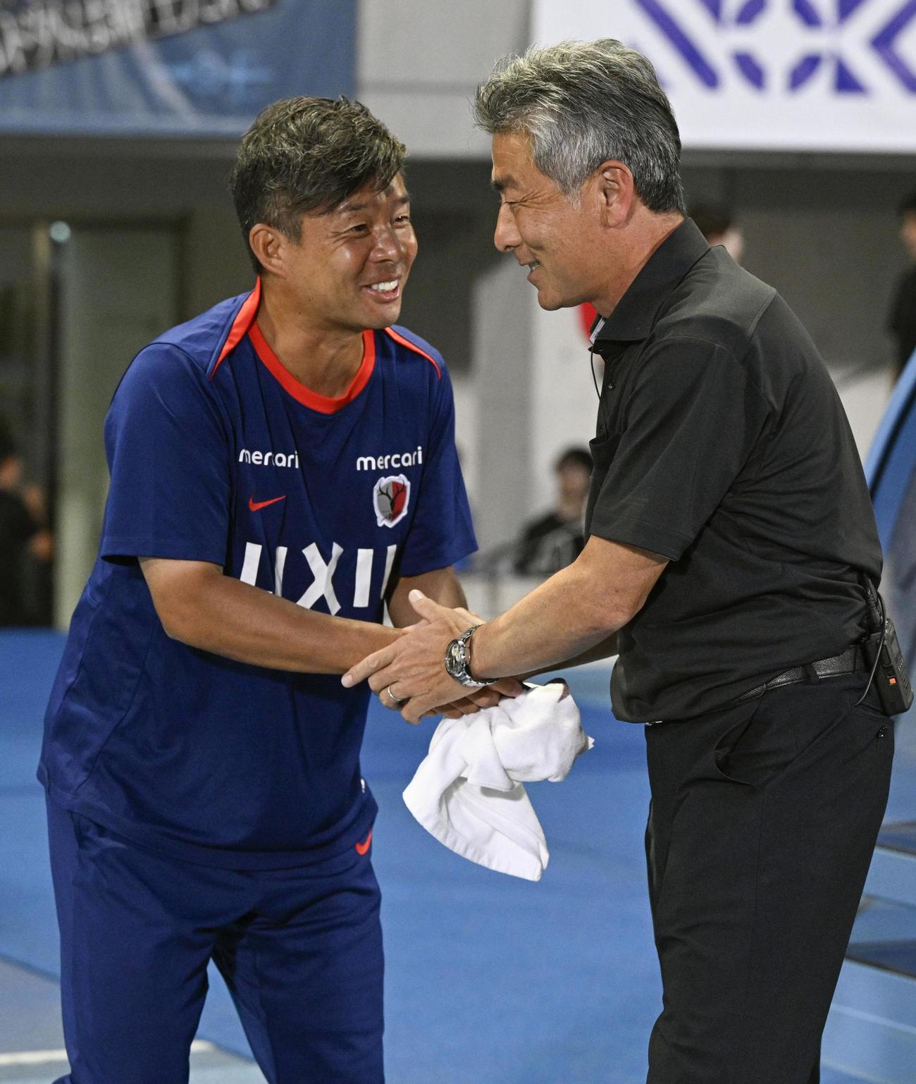 握手を交わす鹿島・鬼木監督（左）と川崎・長谷部監督（共同）
