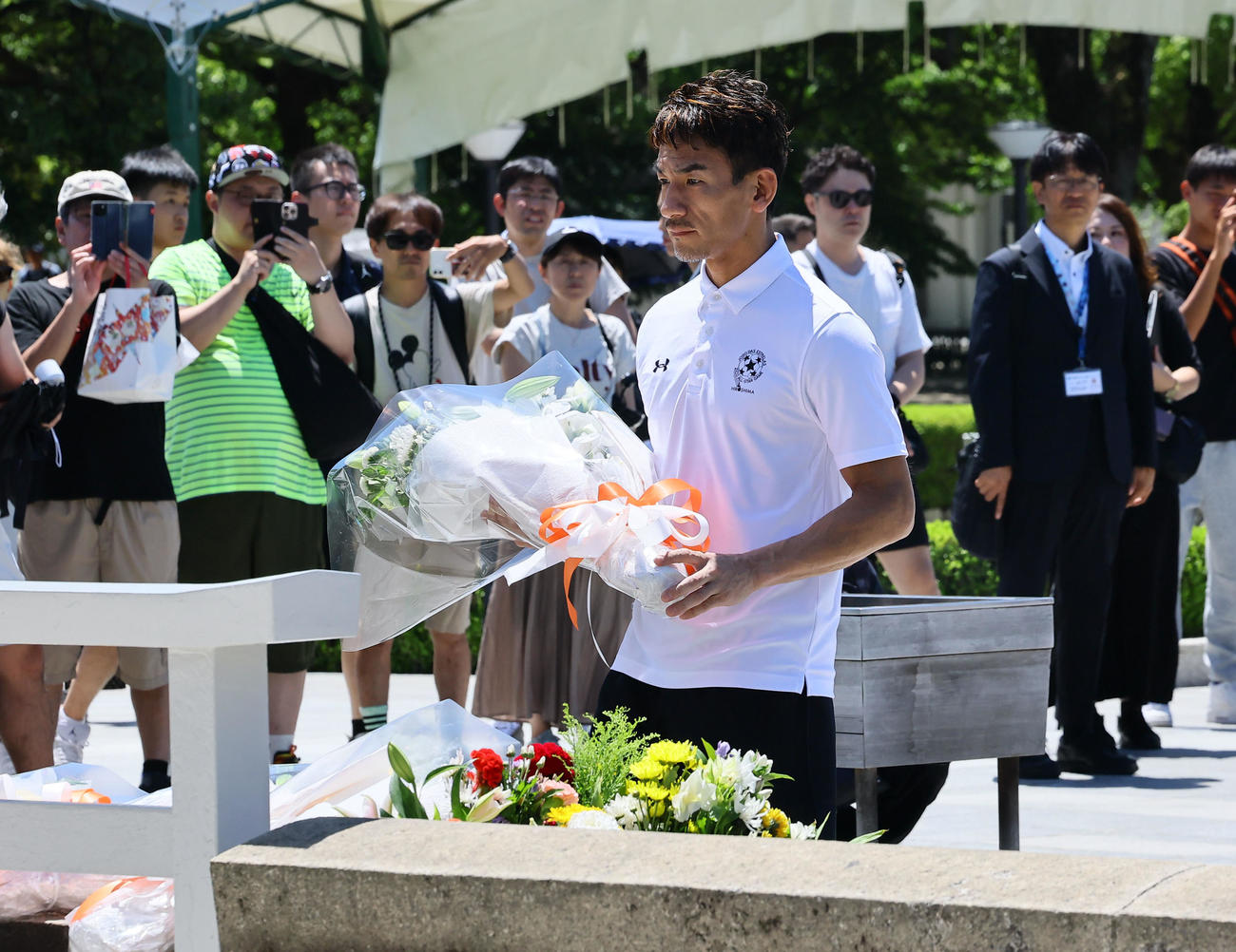 原爆死没者慰霊碑に献花する中田英寿氏。後方右からジーコ氏、中田浩二氏、小野伸二氏（撮影・藤尾明華）