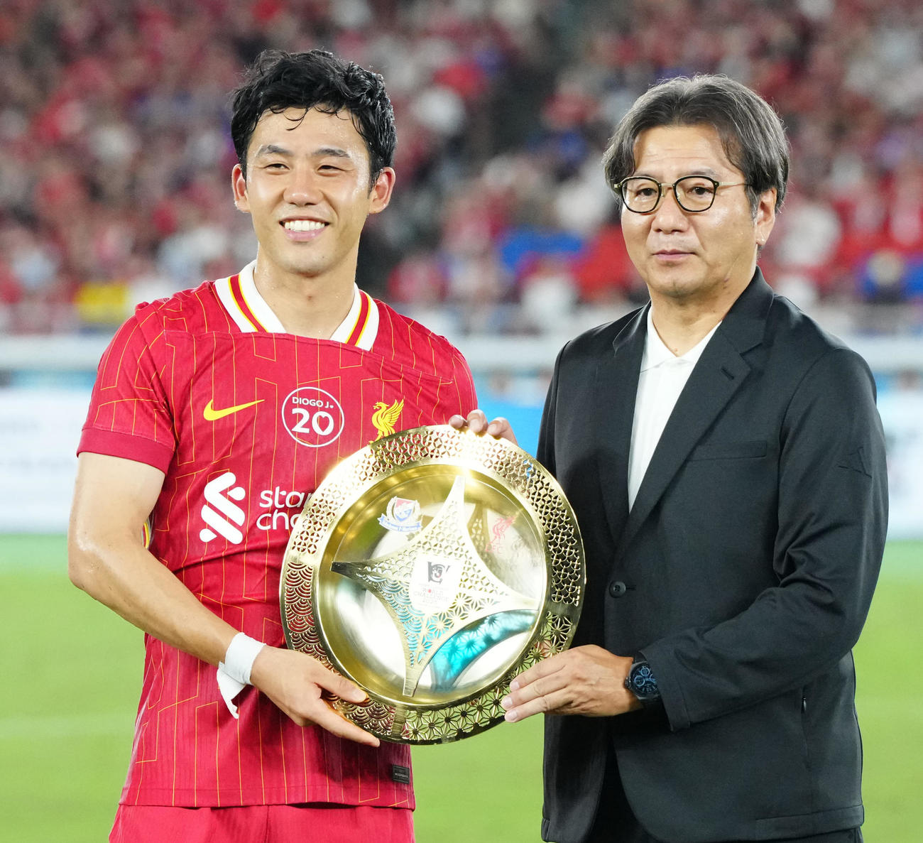 横浜対リバプール　試合後、プレートをJリーグ野々村チェアマン（右）から受け取るリバプール遠藤（撮影・江口和貴）