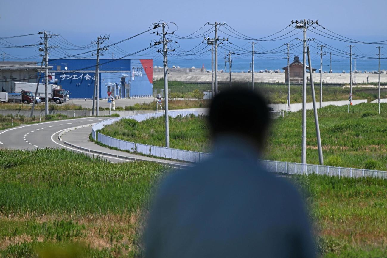 津波警報が発令され、海の近くから高台に避難した人（30日午後0時36分、福島県浪江町）