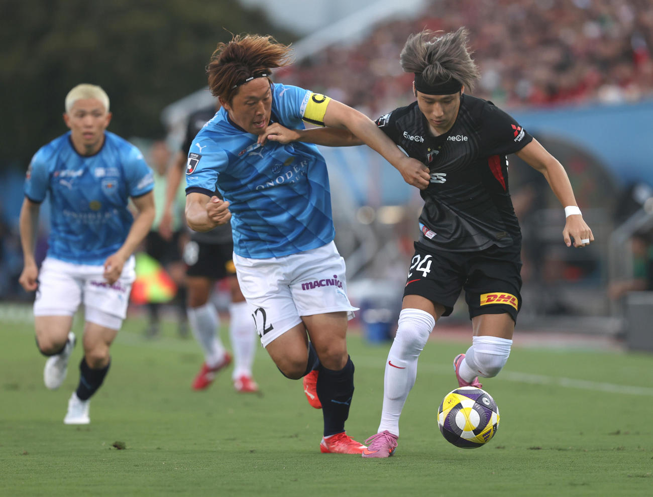横浜FC対浦和　前半、激しくボールを奪い合う横浜FC岩武（左）と浦和松尾（撮影・水谷安孝）