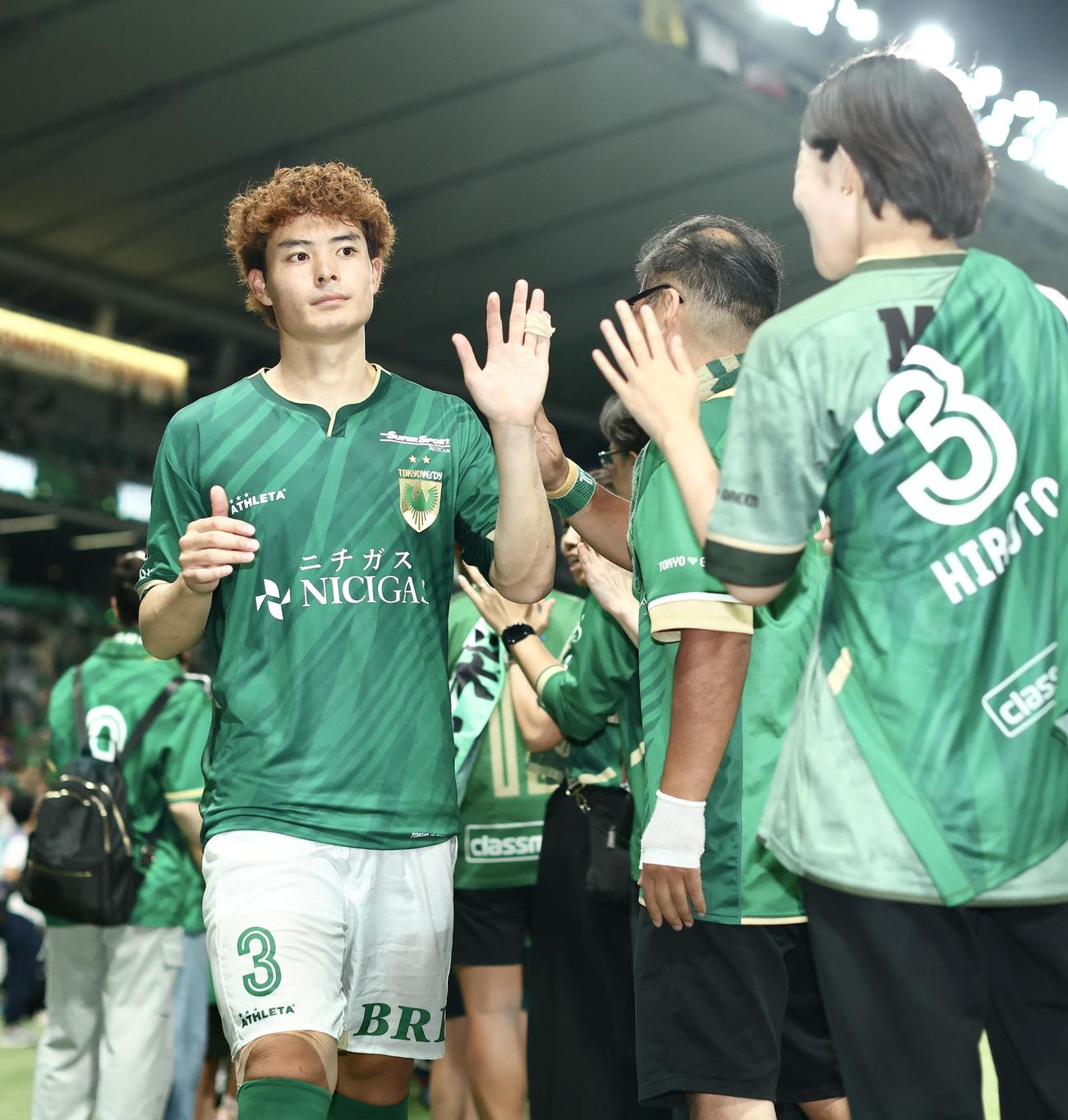 東京V対横浜　横浜に勝利し、サポーターとタッチを交わす東京V谷口（左）（撮影・河田真司）