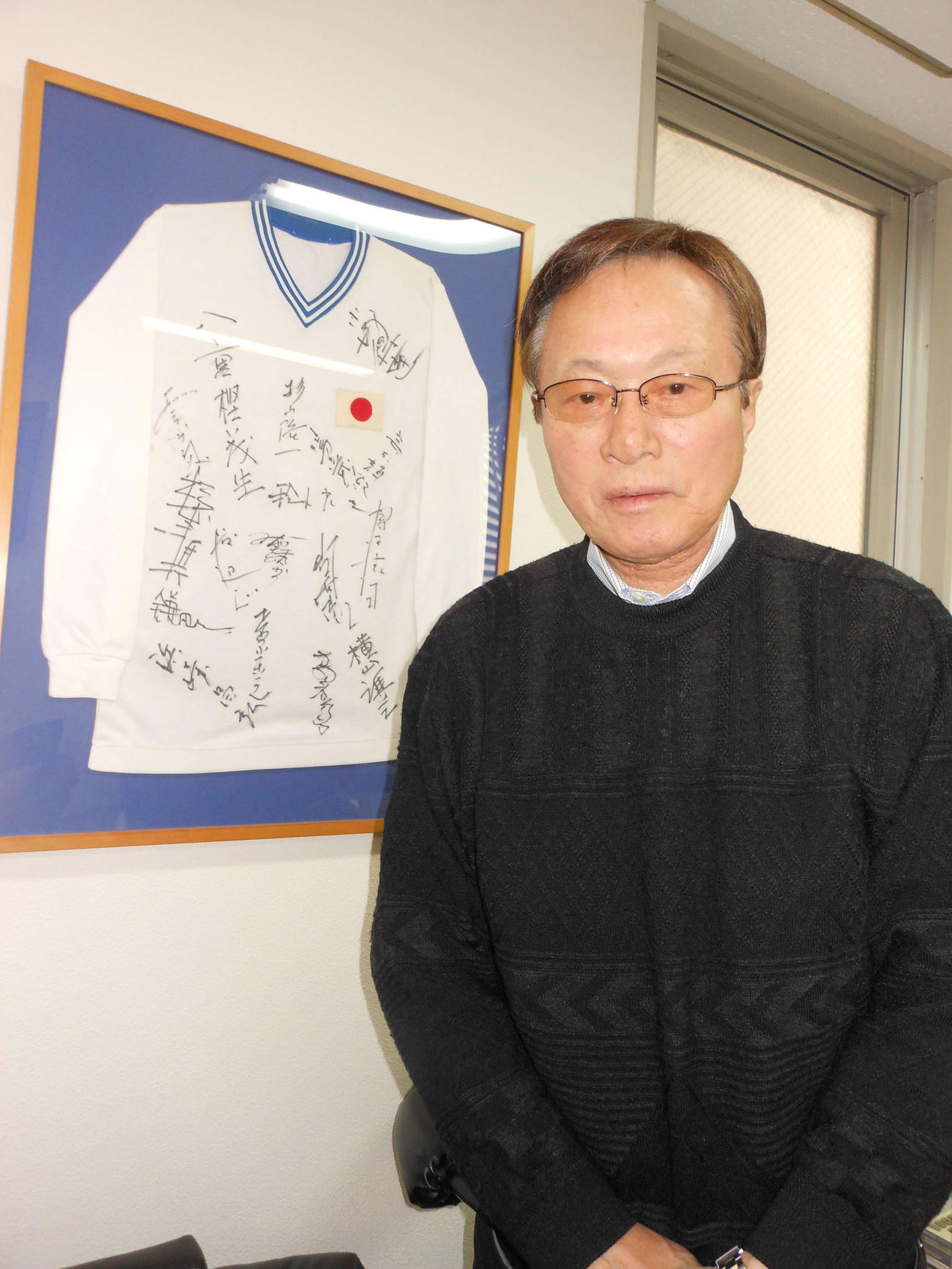 五輪代表メンバーのサイン入りユニホームを前に思い出を語る釜本邦茂氏