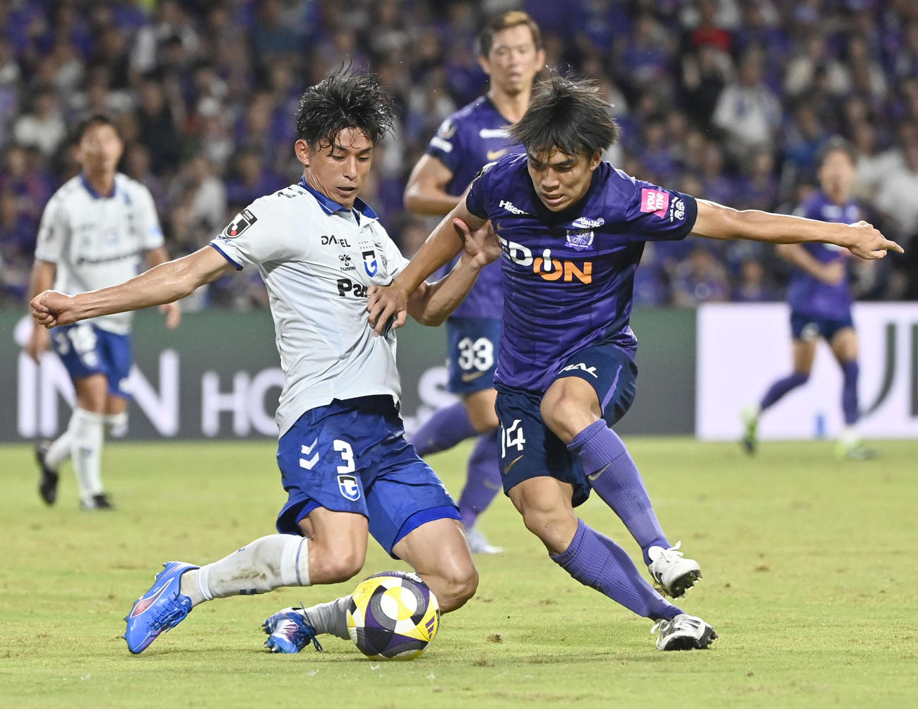 後半、競り合うG大阪・半田（左）と広島・田中聡（共同）