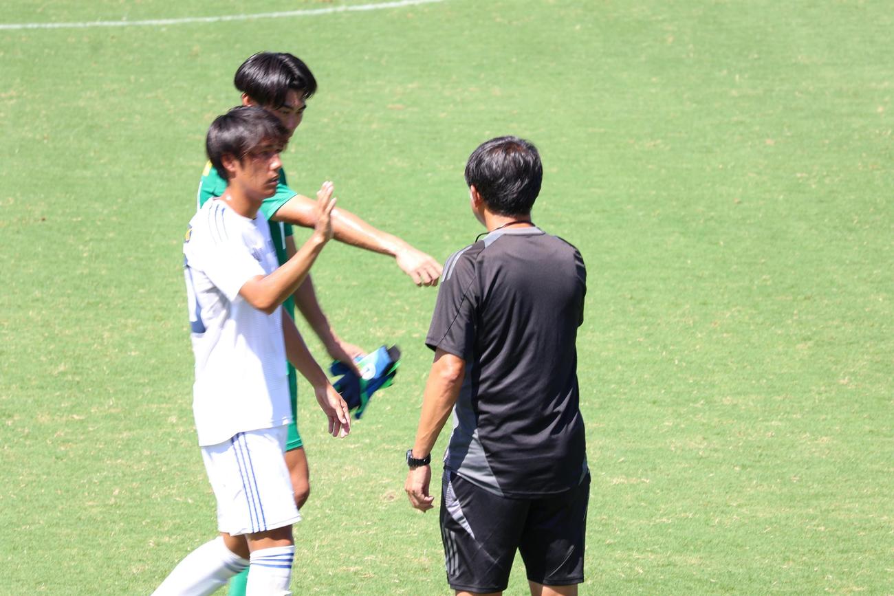 練習試合を終えた大阪学院大MF遠藤楓仁（左手前）は実好礼忠監督（右）とあいさつ