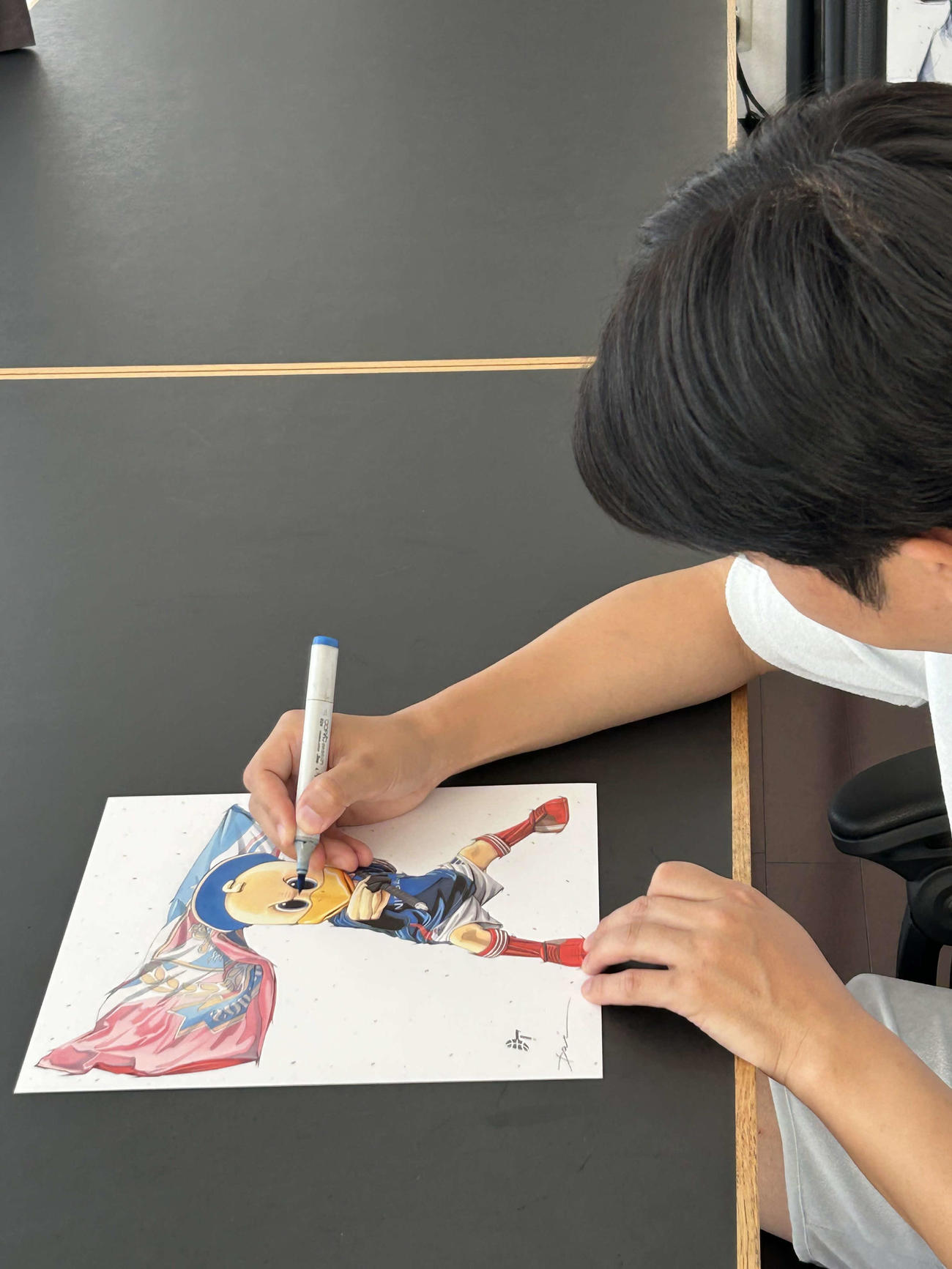イラストに色づけする田村大さん