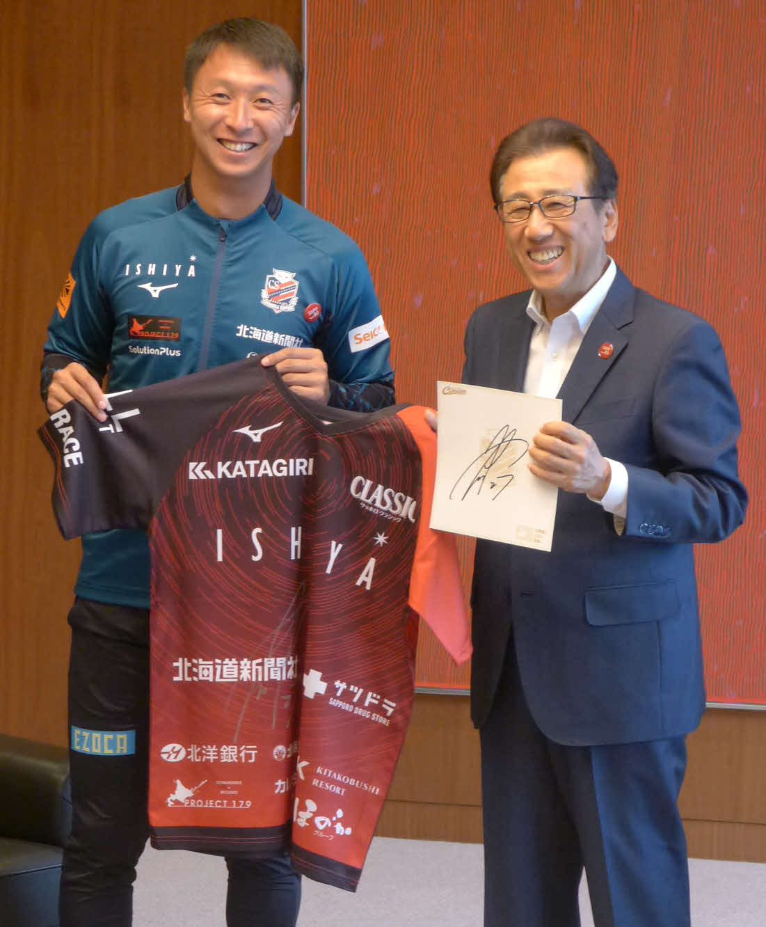 札幌荒野（左）は秋元市長にサイン入りユニホームと色紙を贈る
