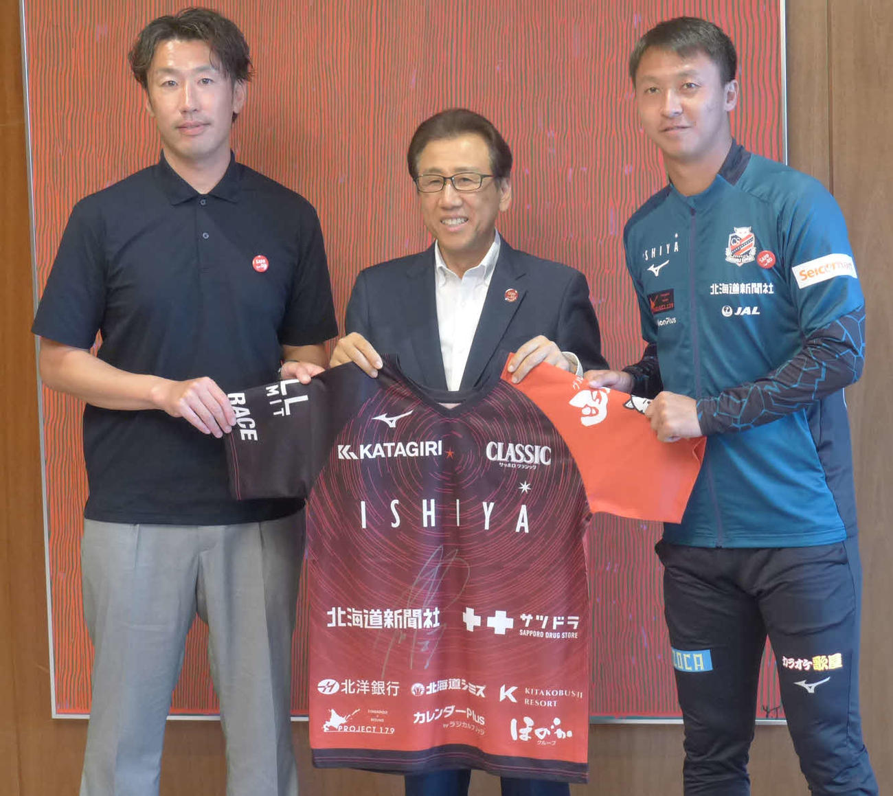 札幌荒野（右）は秋元市長（中央）にサイン入りユニホームを贈る。左は柴田監督