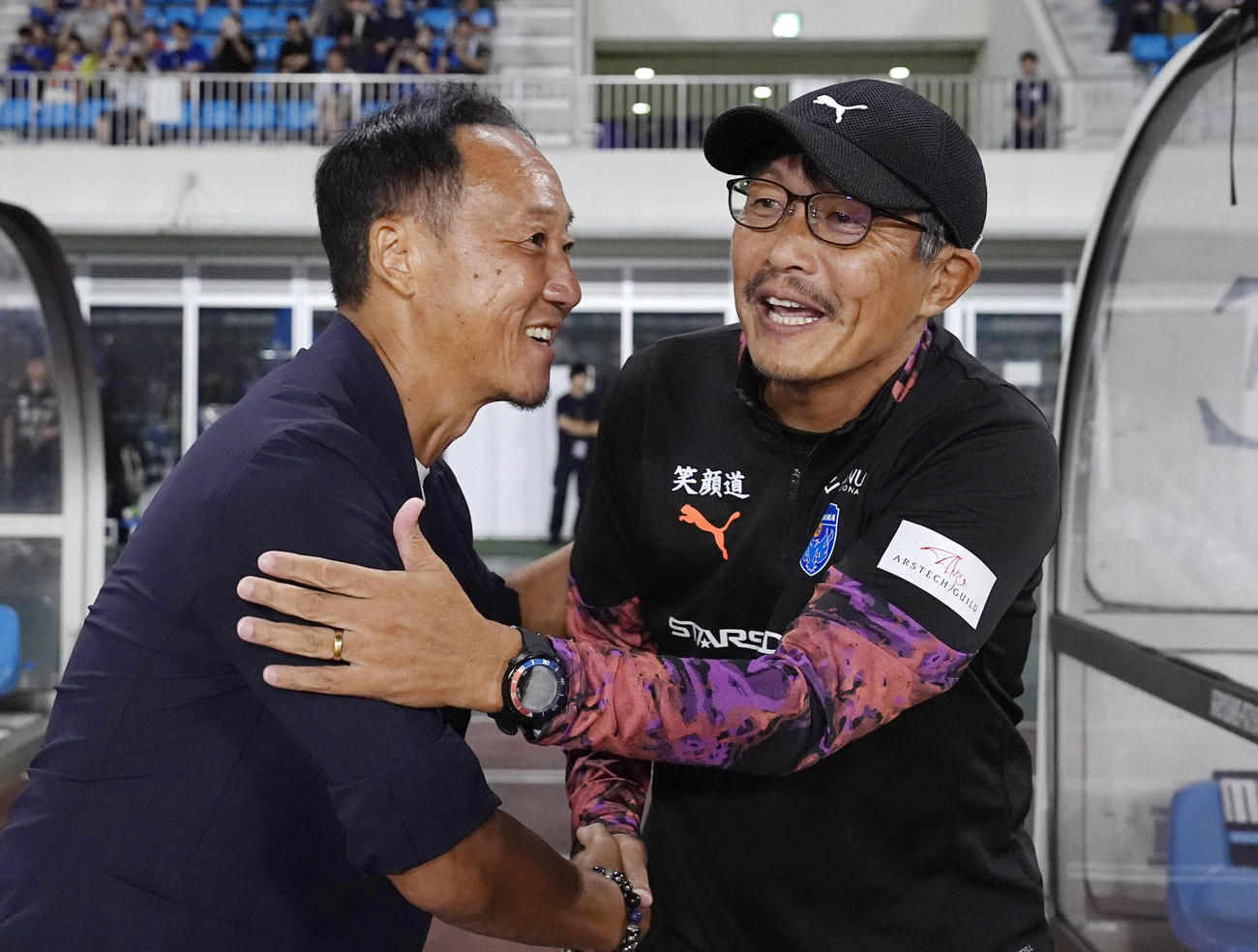 試合前、あいさつする横浜FC三浦監督（右）と町田黒田監督（共同）