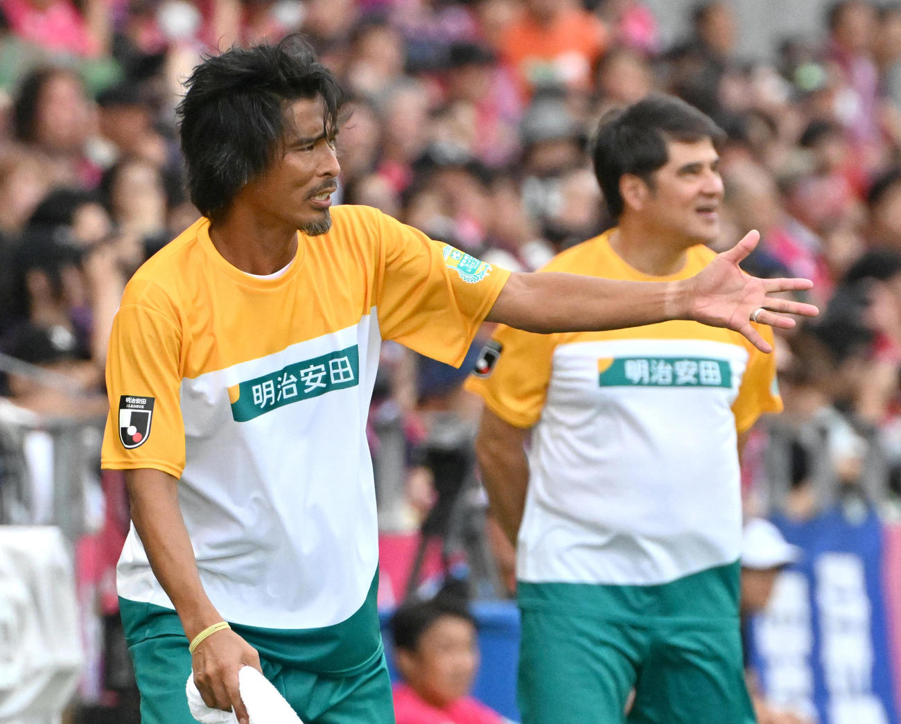 明治安田スーパーレジェンズ対C大阪レジェンズ　後半、選手を応援する明治安田スーパーレジェンズの中沢氏（左）。右は永島監督（撮影・石井愛子）