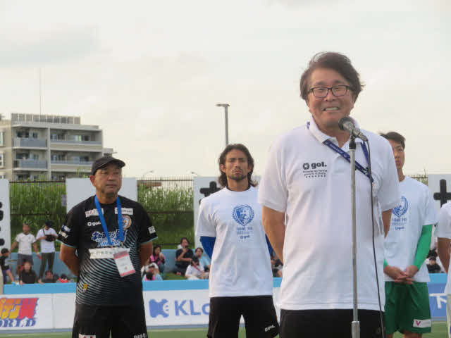 ファン・サポーターにあいさつする南葛SCオーナー兼代表取締役社長の高橋陽一氏。左端は風間八宏監督