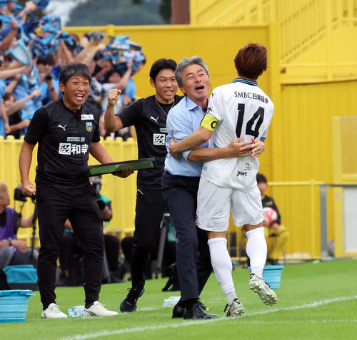 柏対川崎F　前半、先制ゴールを決めた川崎F脇坂（右）は長谷部監督と抱き合って喜ぶ（撮影・山本朝陽）