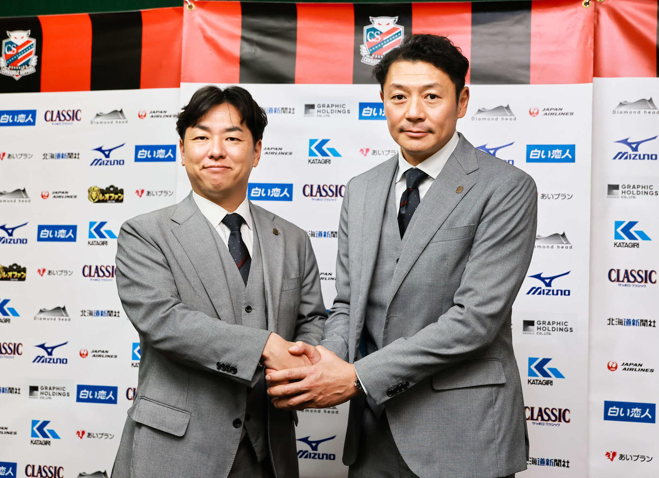 12月12日付けでGMに就任する河合竜二氏（右）と石水肇社長が握手する